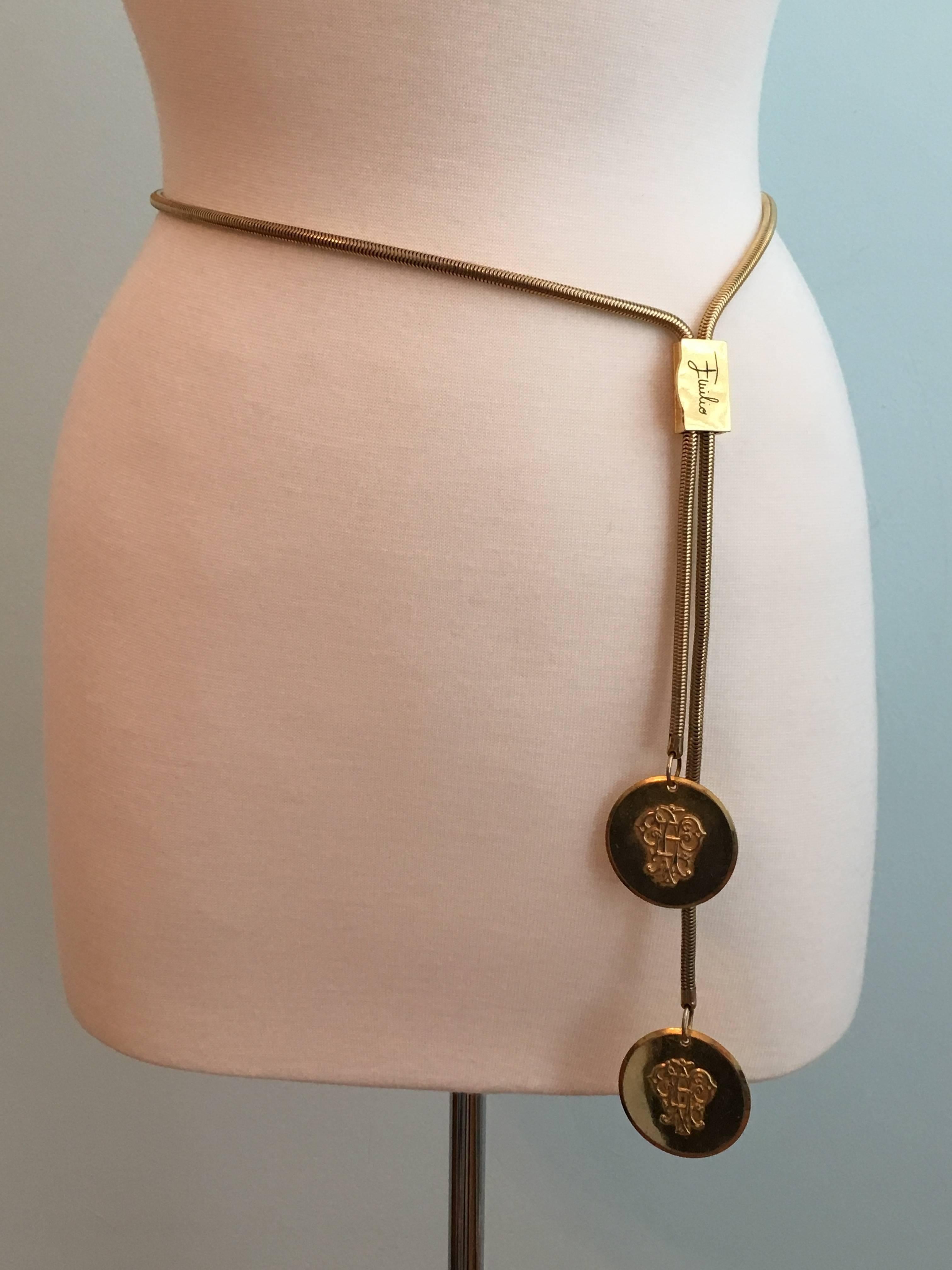 This is a vintage 1960s Emilio Pucci gold-tone snake chain belt. It has a total length of 42 1/4" long. It is adjustable and can be worn at the waist or at the hips. It can be adjusted up to 36 1/2". Each end of the belt has a gold-tone