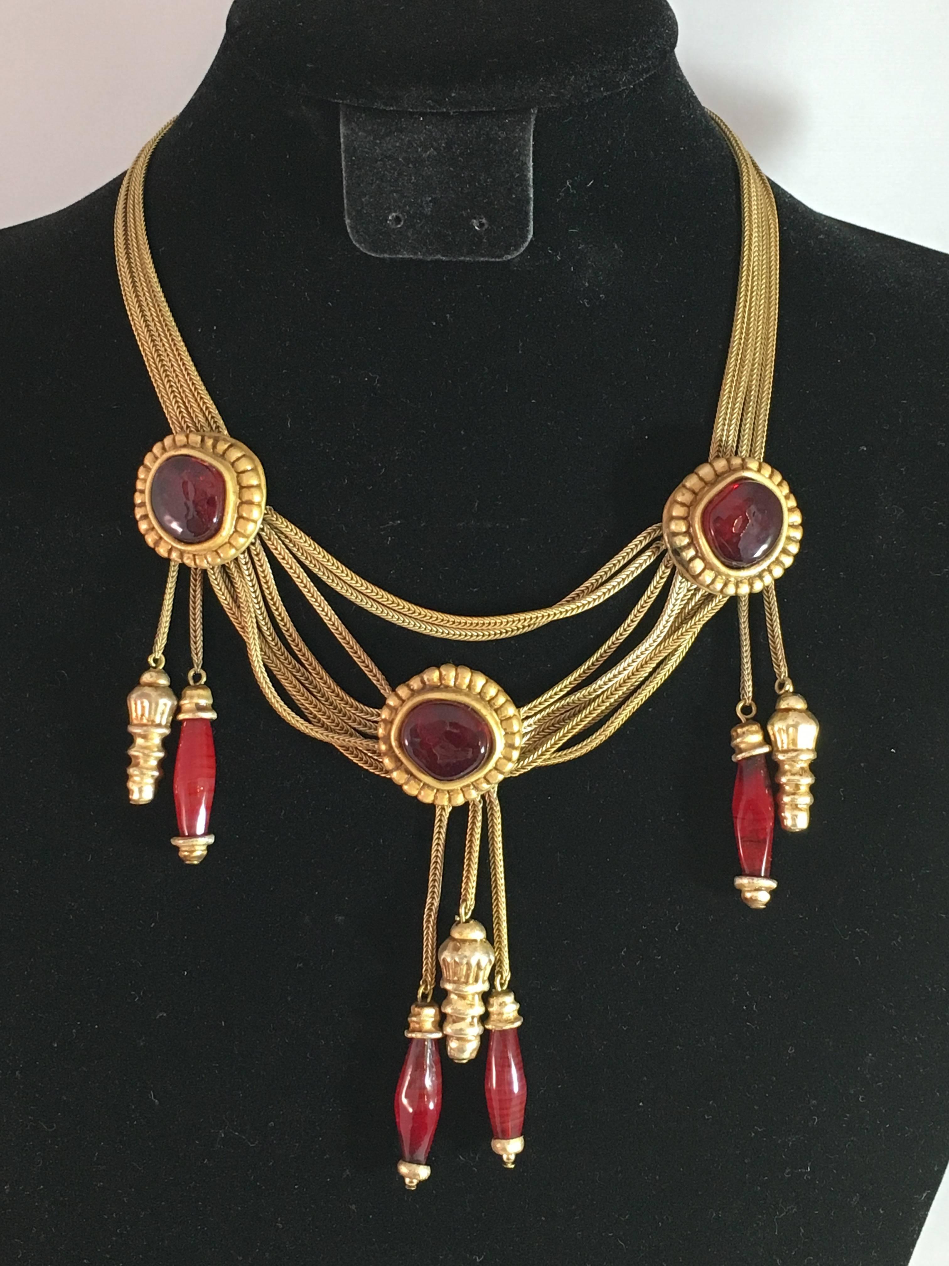This is an amazing 1980s Christian Dior Boutique necklace with dark red gripoix glass medallions and hanging gripoix glass beads. The necklace measures 16" and is made up of multiple goldtone chains and three gripoix glass medallions with oval