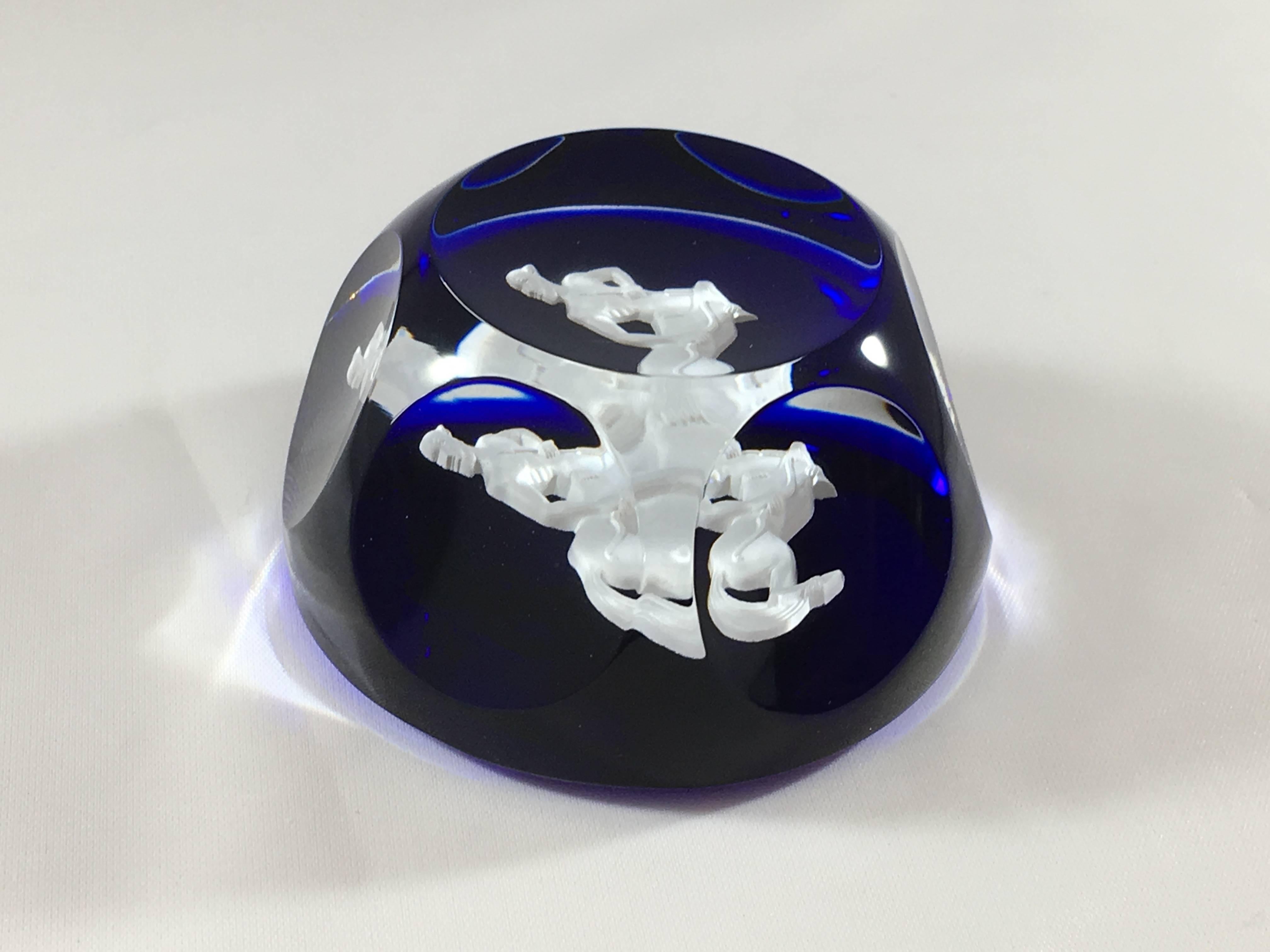 This is a 1970s colbalt blue and white sulphide Sagittarius paperweight made by Baccarat. It has six faceted sides. It is 1 3/4