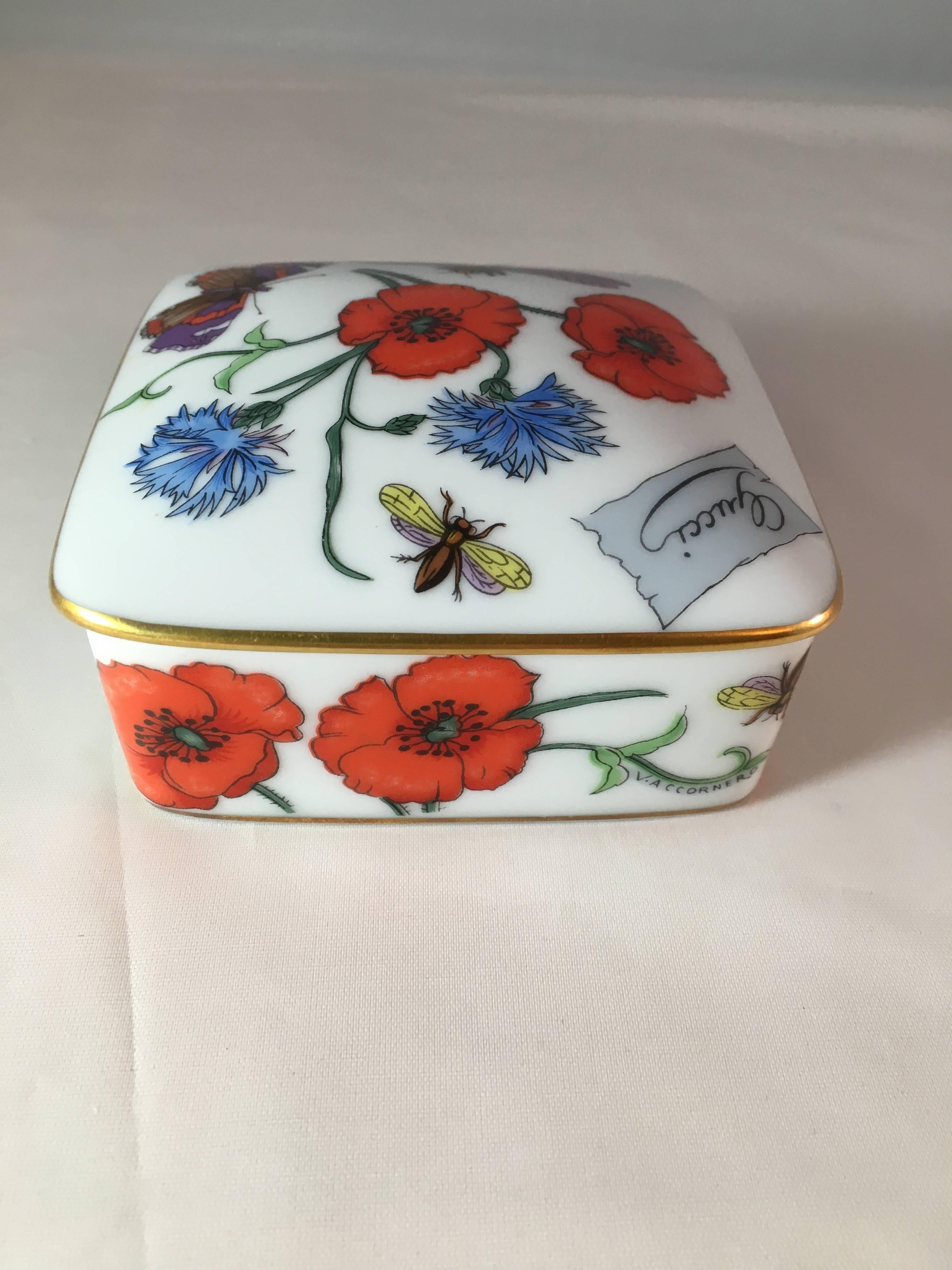 This is a 1970s Gucci floral porcelain trinket box made by Bernardaud Limoges. It is decorated with the iconic 'Flora' pattern designed for Gucci in 1965 by artist Vittorio Accornero. The top of the box is marked 'Gucci' and the back is marked,