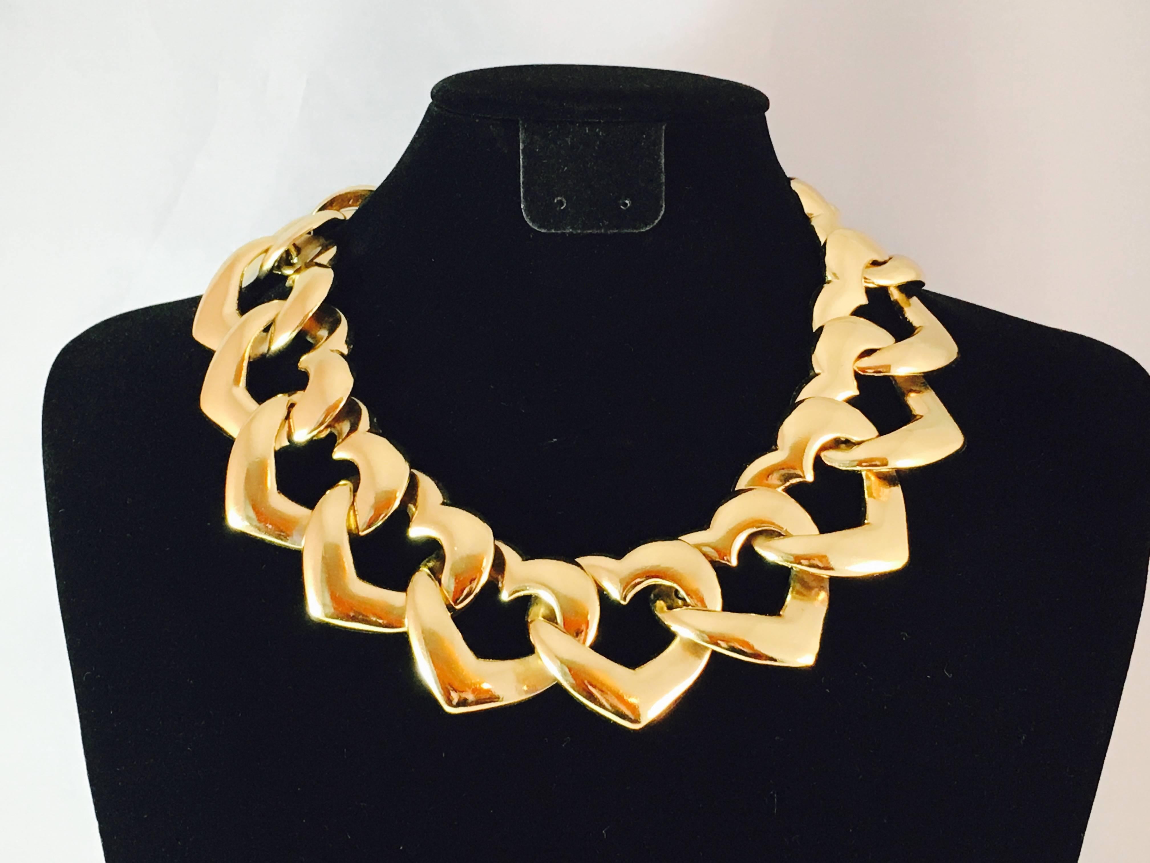 This is a vintage Yves Saint Laurent necklace made up of hearts. It is 1 1/2 inches wide. It is adjustable and can be worn at 16 inches or up to 18 inches. It is marked 'YSL' on a hanging plaque attached at the closure. The other side of the plaque