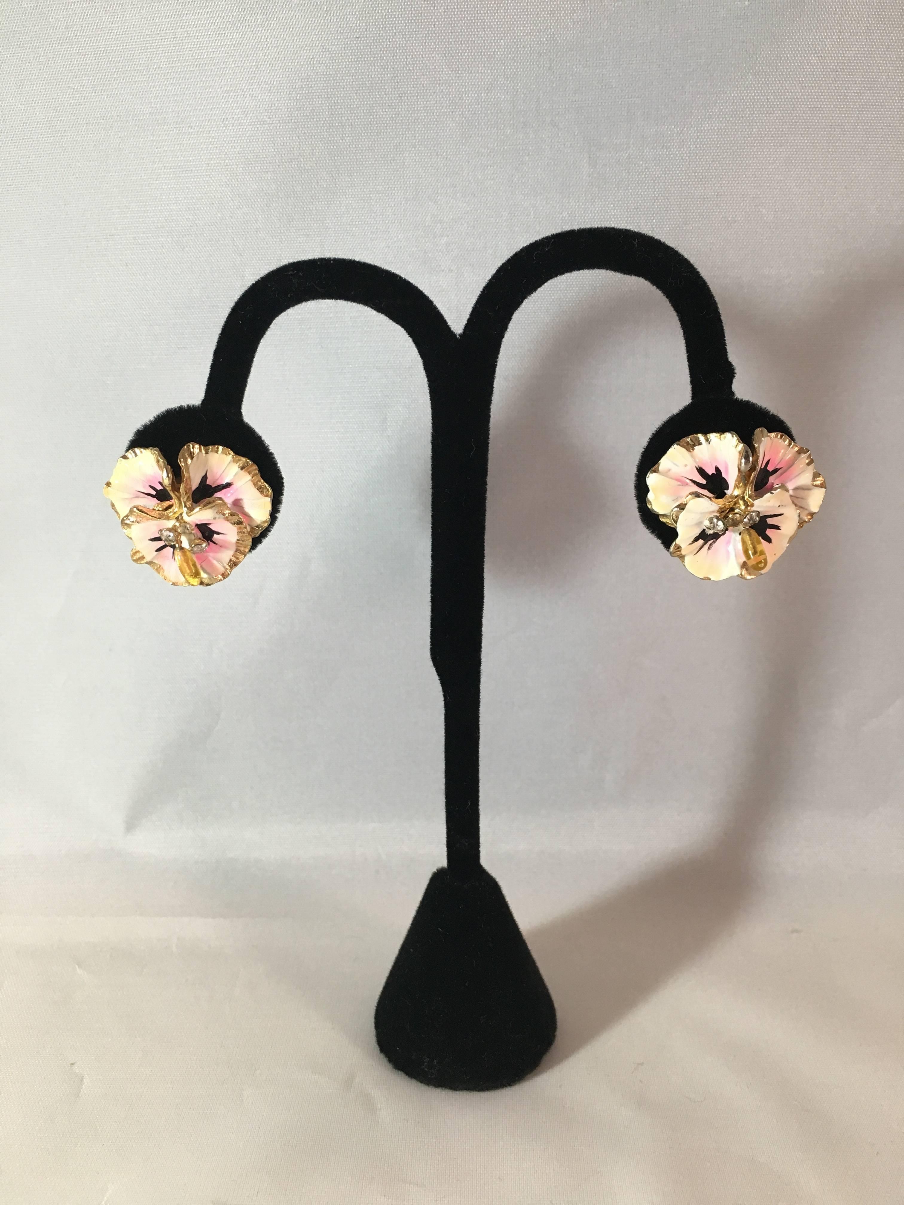 This is a fabulous pair of 1950s pink enamel pansy clip-on earrings. Each earring has clear rhinestones and a yellow citrine resin bead in the center. They measure 1