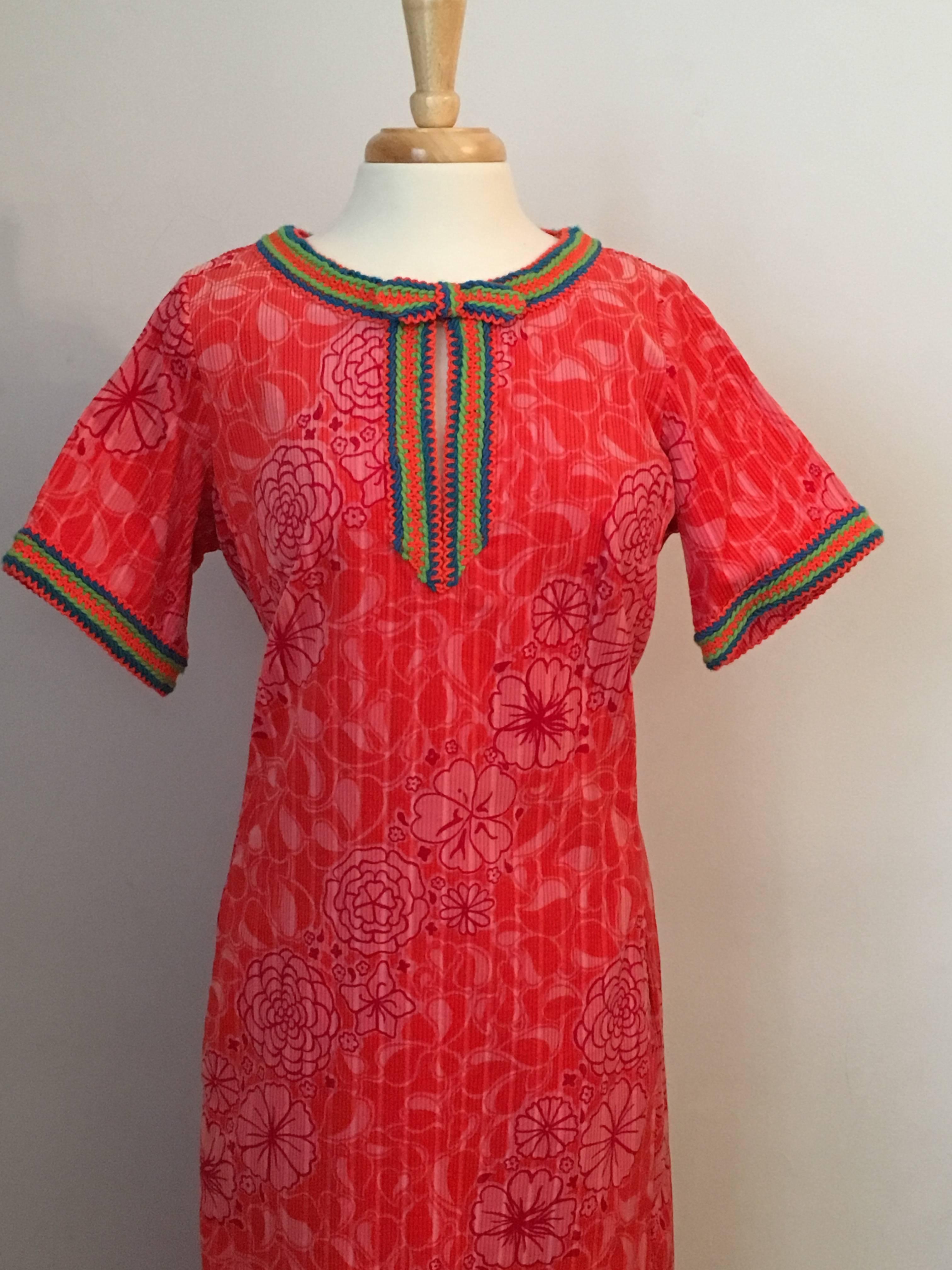 This is a rare Lilly Pulitzer piece from the 1960s. It is a printed corduroy caftan with knit crochet stripe trim. The printed corduroy is pink and orange and the crochet trim is orange, green and blue. I have never seen another one like it. It is
