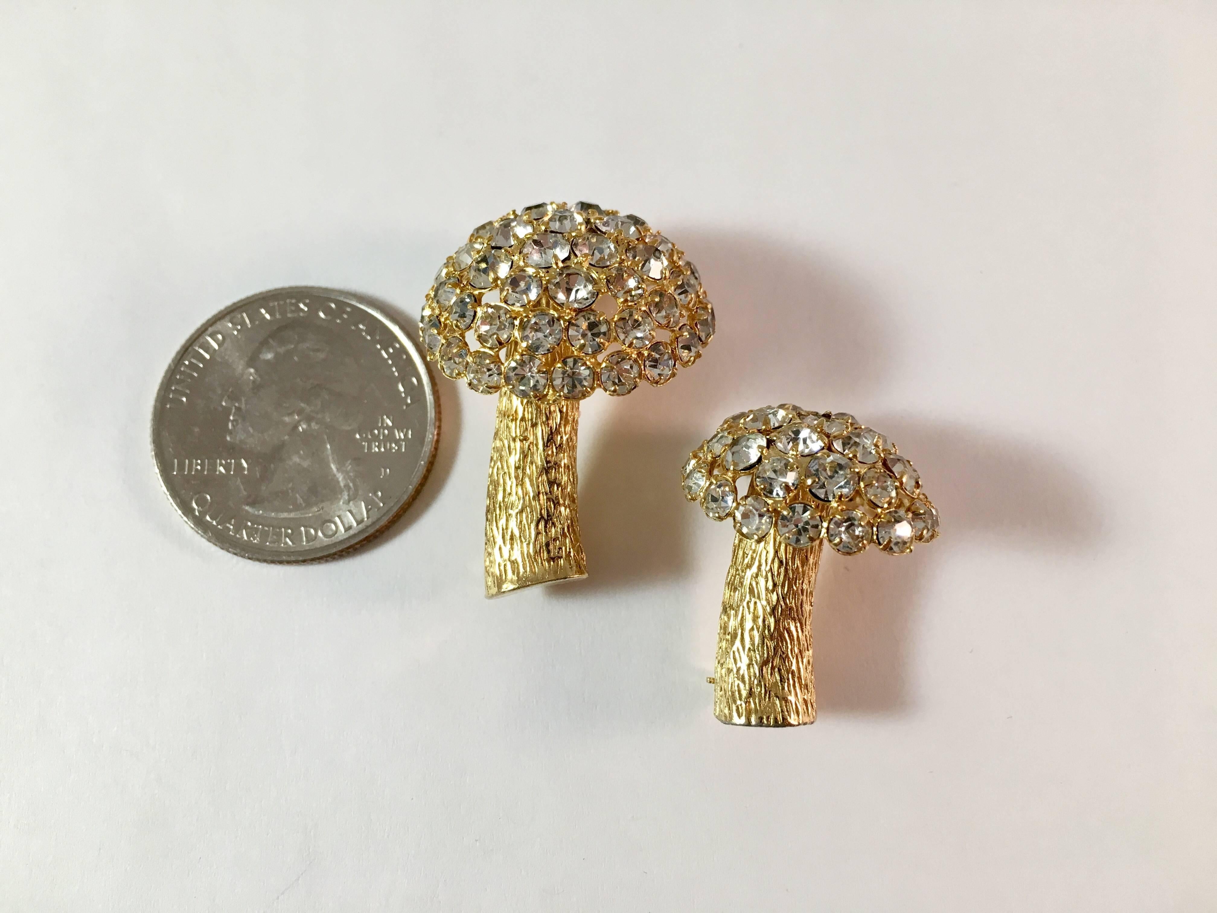 Love these fun 1960s mushroom brooches from Castlecliff. They are made up of clear rhinestones set in a goldtone metal. One is slightly larger than the other, measuring 1 1/4" tall x 1" wide. The other measures 1"tall x 3/4"wide.