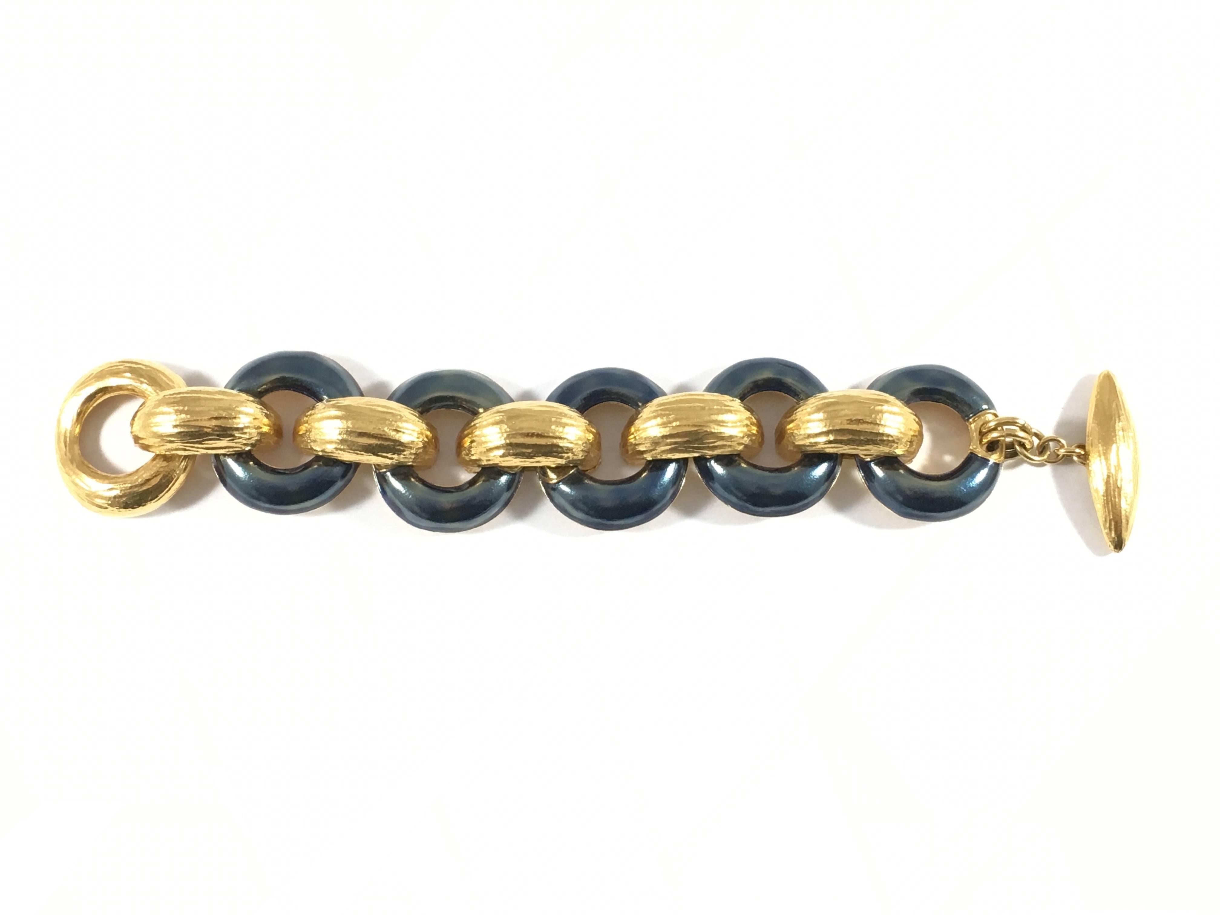 This beautiful 1980s bracelet is from Yves Saint Laurent's Rive Gauche line - the pret-a-porter line made especially for their Rive Gauche Boutiques. The bracelet is made up of heavy goldtone metal links interspersed with links covered in a