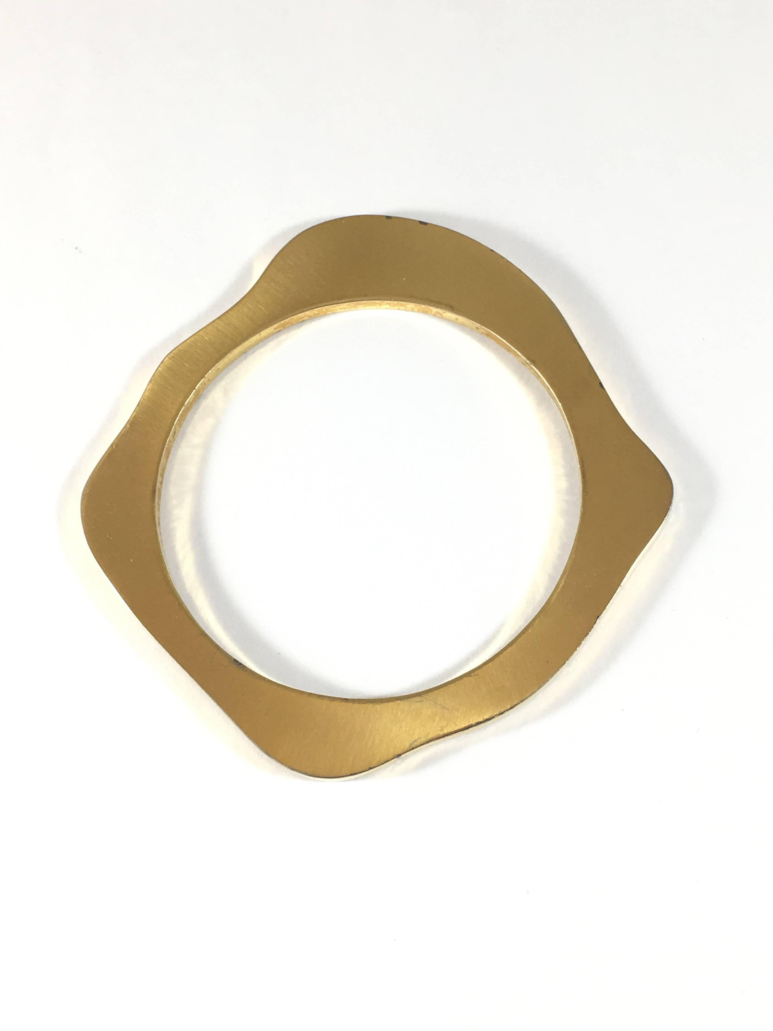 This is a MOD 1960s Pierre Cardin goldtone bangle bracelet. The interior diameter measures 2 1/2 inches. It is signed 'Pierre Cardin' on one side. The bracelet is in overall good condition with the exception of some places where there is war to the