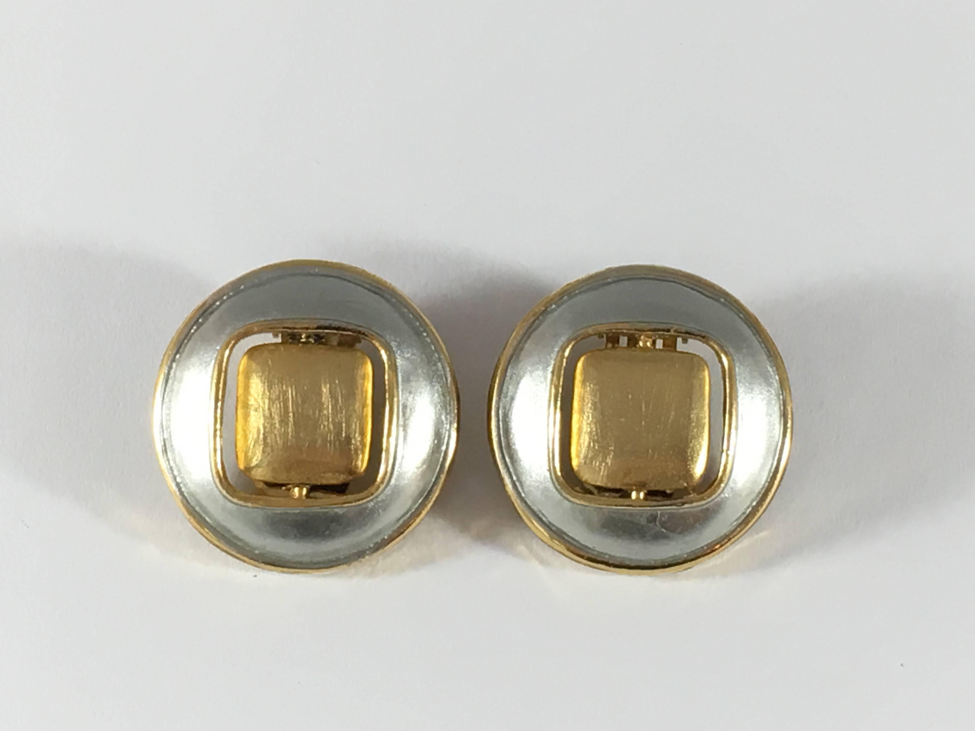 These earrings are MOD Pierre Cardin clip-on earrings are from the 1960s. They measure 1 inch in diameter and have reversible disks - one side is goldtone and the other is black enamel. They are marked 'Pierre Cardin' on the back. They are in