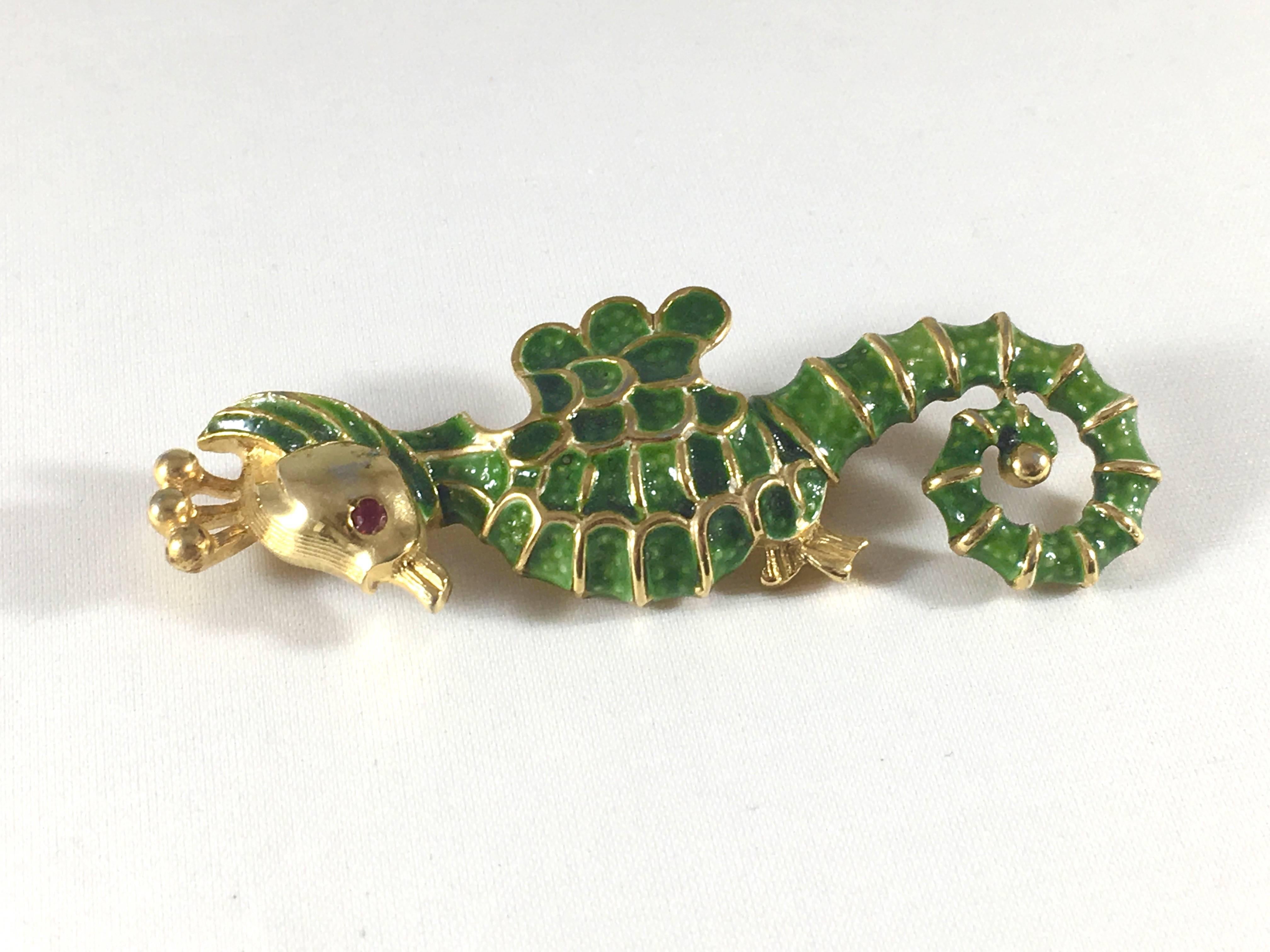 This adorable seahorse brooch was made by Kenneth Jay Lane in the 1960s. It is a gold-tone metal with green enamel and a red rhinestone used for the eye.
It is marked on the back with 'K.J.L.' - the earliest mark used by Kenneth Jay Lane which dates