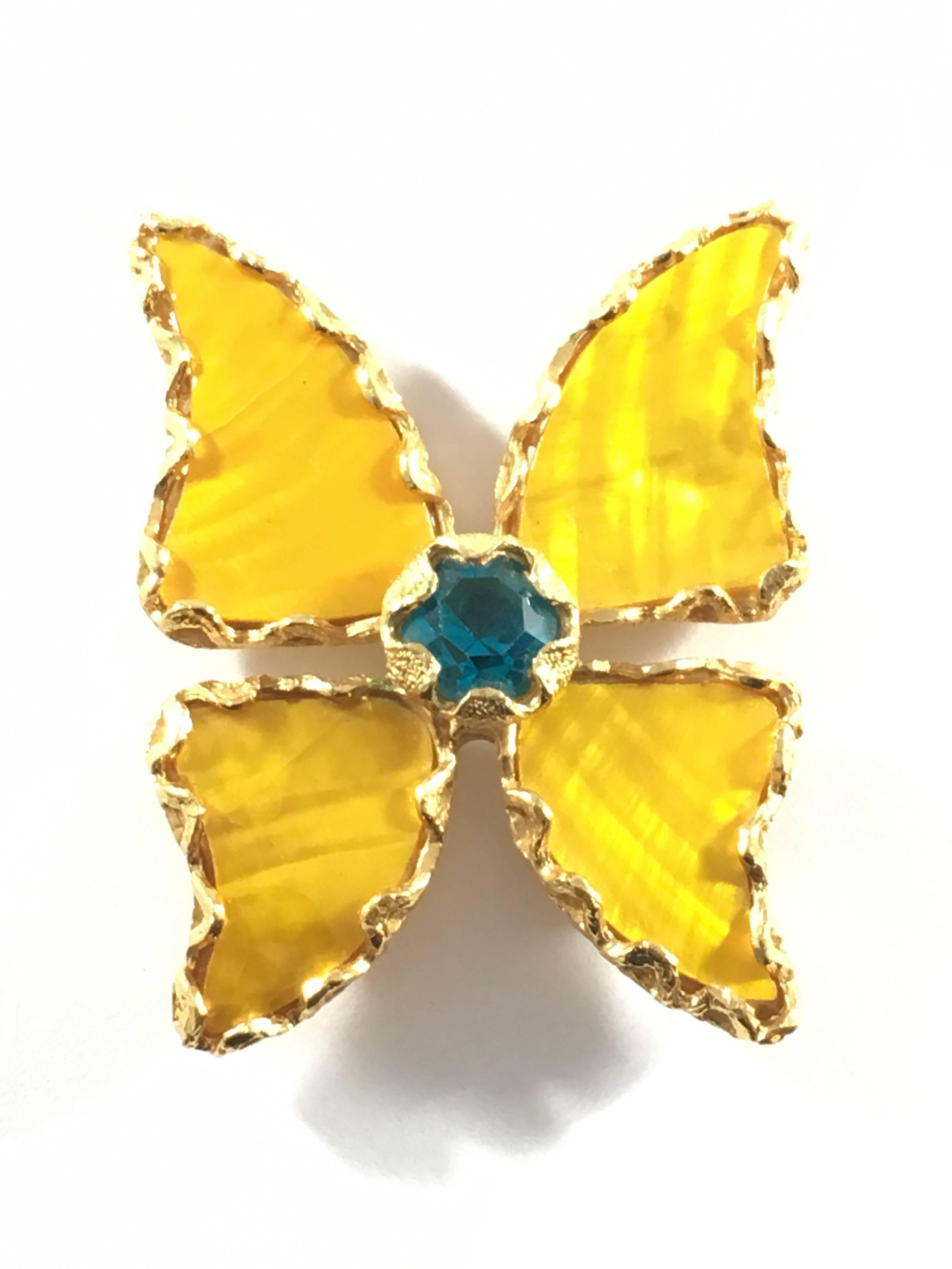 This is a beautiful butterfly brooch from Yves Saint Laurent. It was made for their high-end line, 'Rive Gauche'. The wings are made of very thin yellow shell pieces that have a shimmering mother-of-pearl effect. The center of the butterfly has a