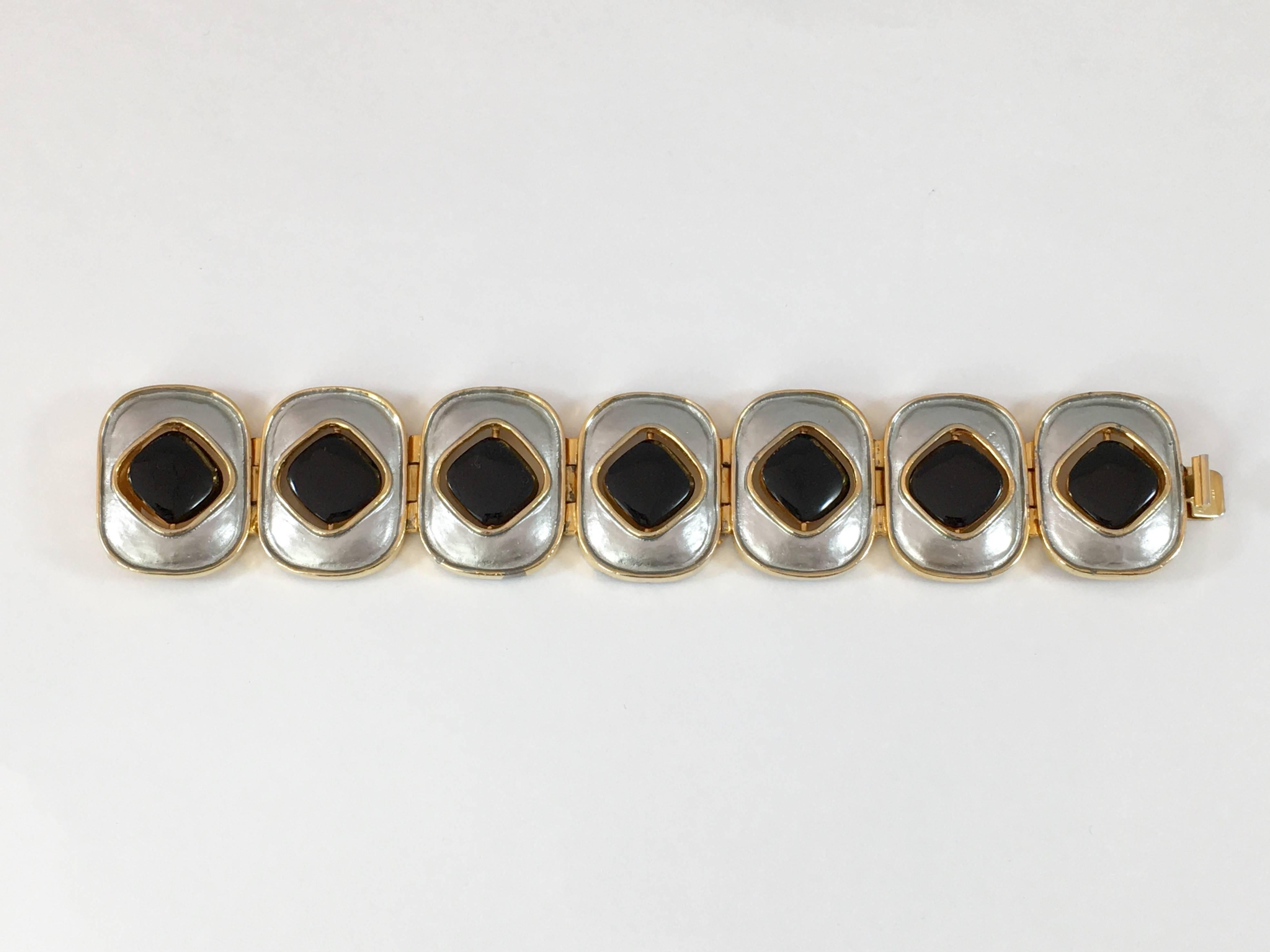 This is a Pierre Cardin Mod 1960s bracelet. The disks that make up the bracelet are reversible - one side is goldtone and the other side is black enamel. They can be worn in any combination of ways. The bracelet is 7 1/4 inches long and  1 1/4