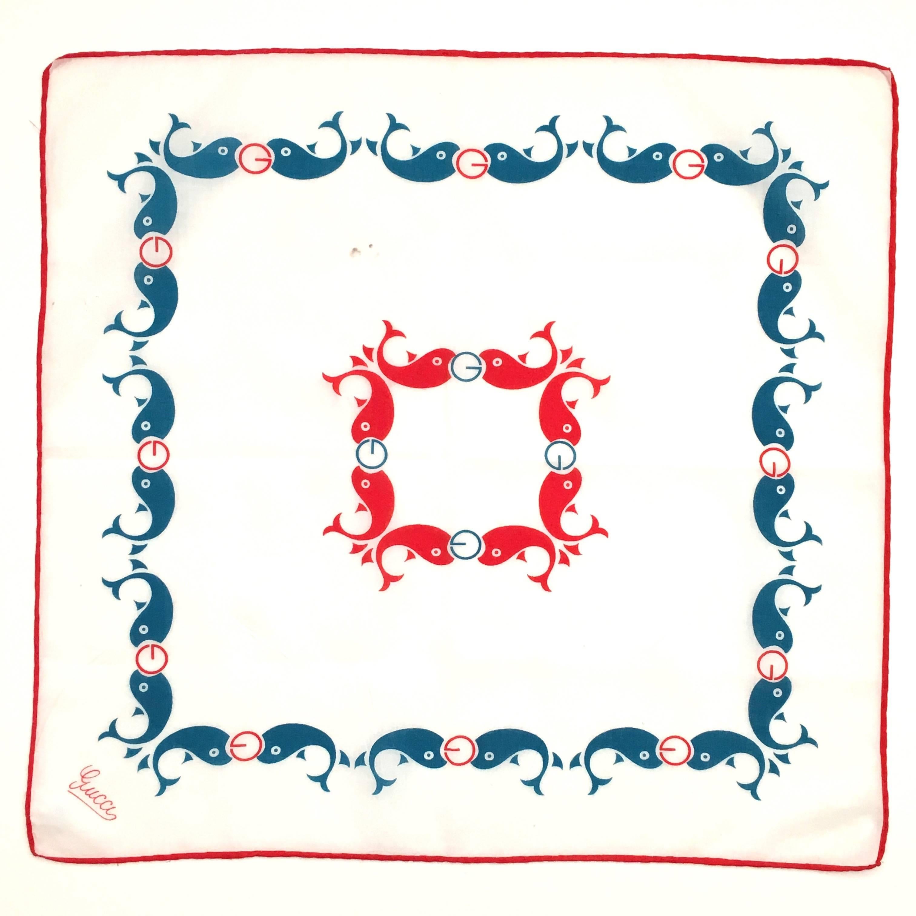 1970s Gucci printed red, white and blue cotton pocket square or small scarf. Printed with red and blue whales holding a Gucci 'G' logo. It is signed with a red 'Gucci' in script in the lower left-hand corner. There is a tag sewn to the back of the