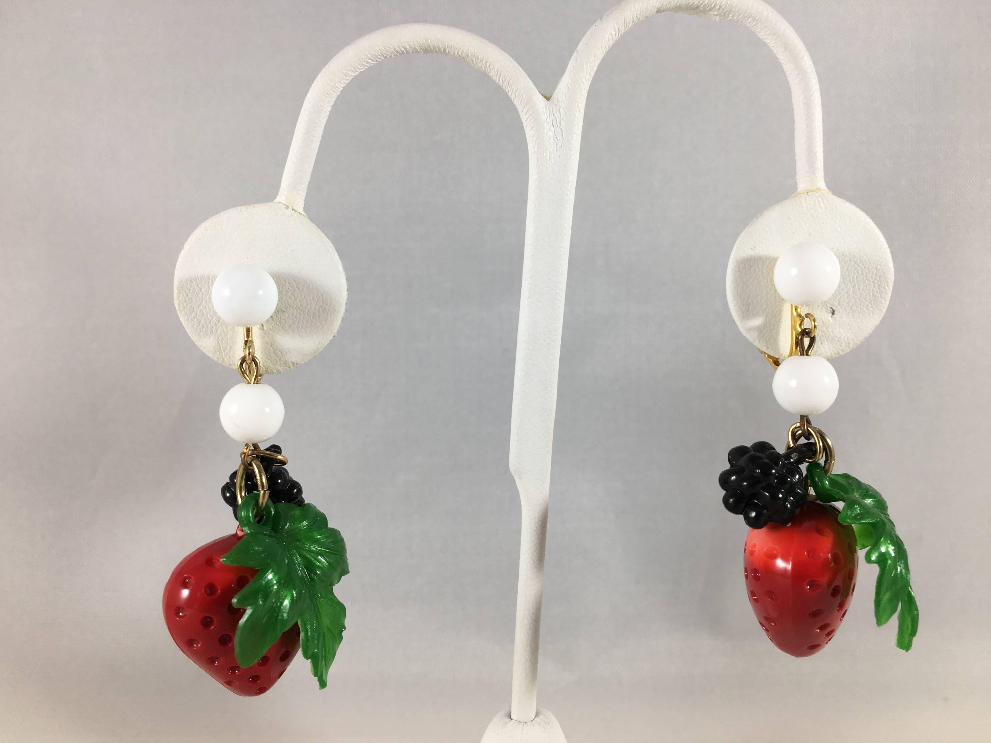 This is an adorable clip-on pair of 1970s strawberry and blackberry earrings from Les Bernard. Each earring features a resin strawberry, leaf, and small blackberry. Each of these pieces are moveable. The earrings are 2 1/4" long by 1"