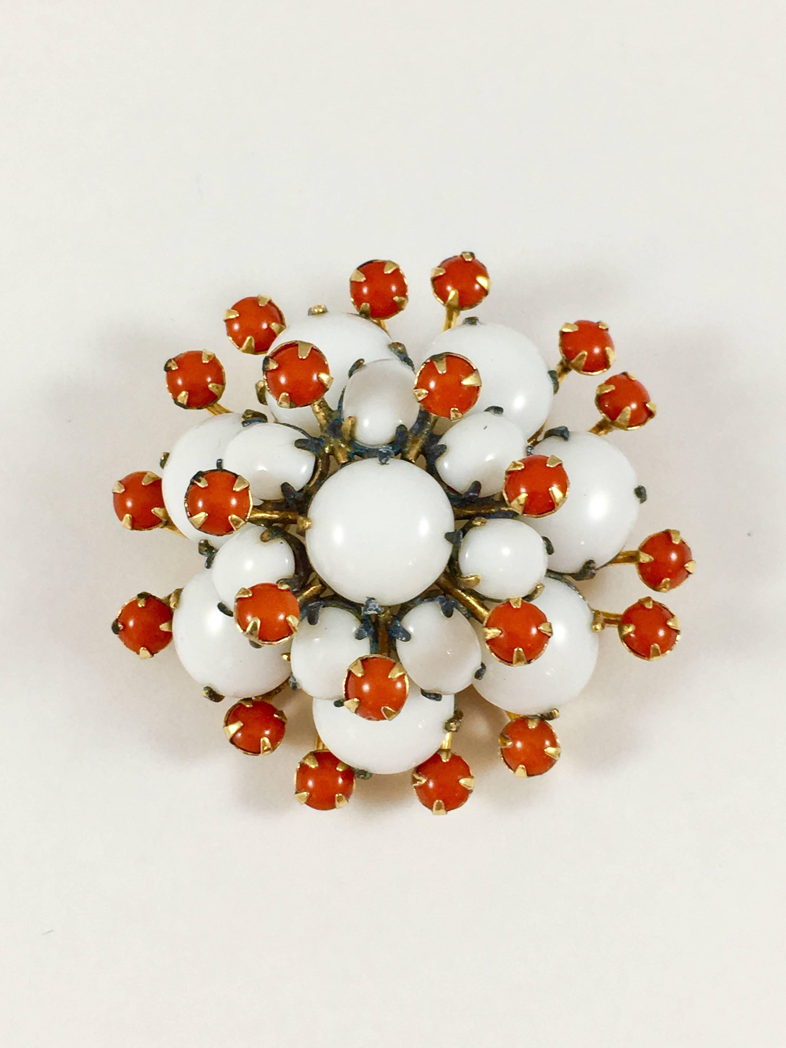 This is an impressive 1950s Schreiner brooch and earring set. The pieces are very three-dimensional. They are made out of a gold-tone base metal and white and orange glass stones. The brooch has a diameter of 1 7/8" and is marked 'Schreiner' in