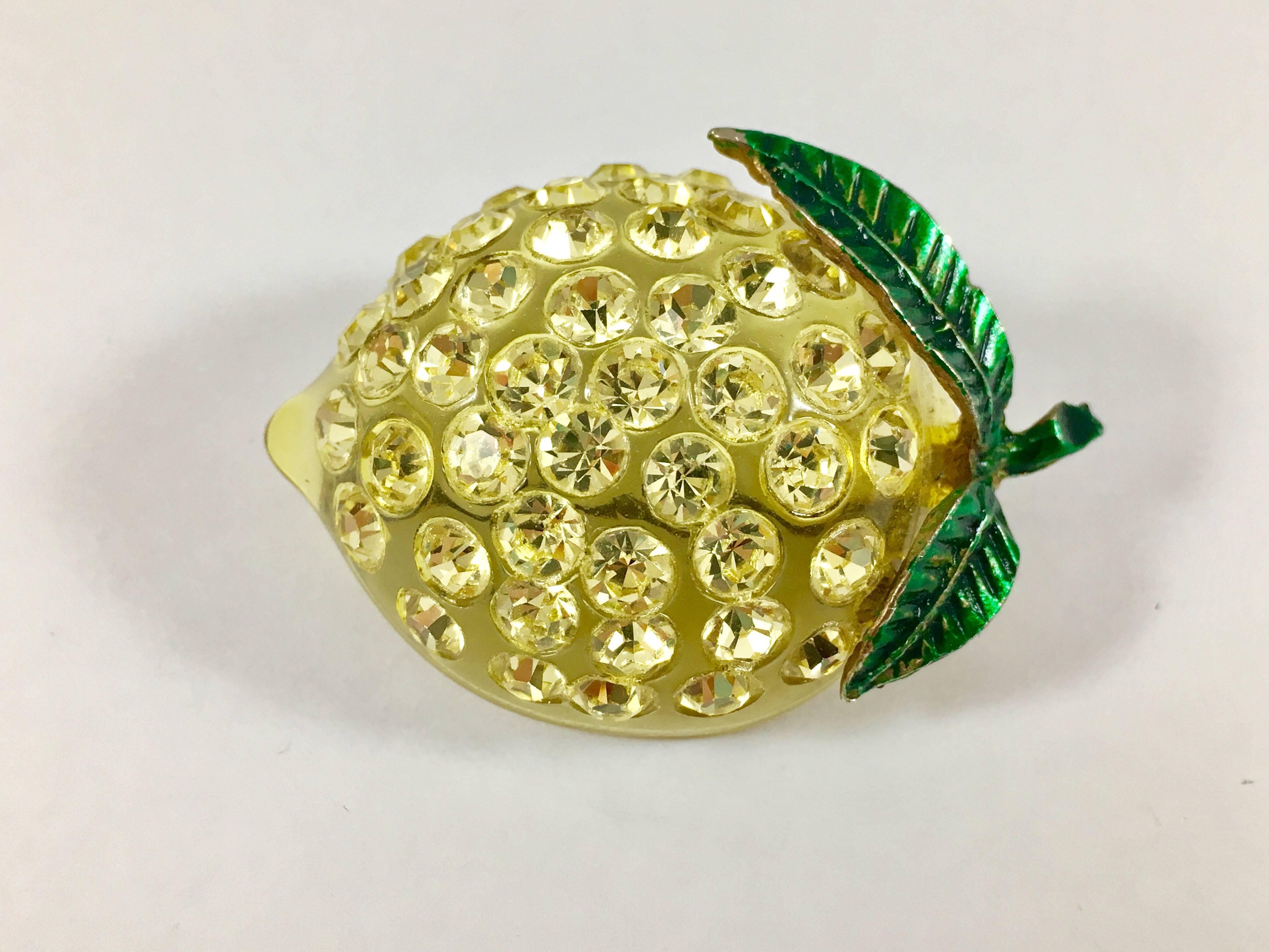 This is a yellow lucite and rhinestone lemon brooch from the 1940s. It has a metal green enameled stem and leaves and measures 2 inches wide x 1 inch tall. It is in excellent condition and so fun for Summer. These pieces were made in Austria in the