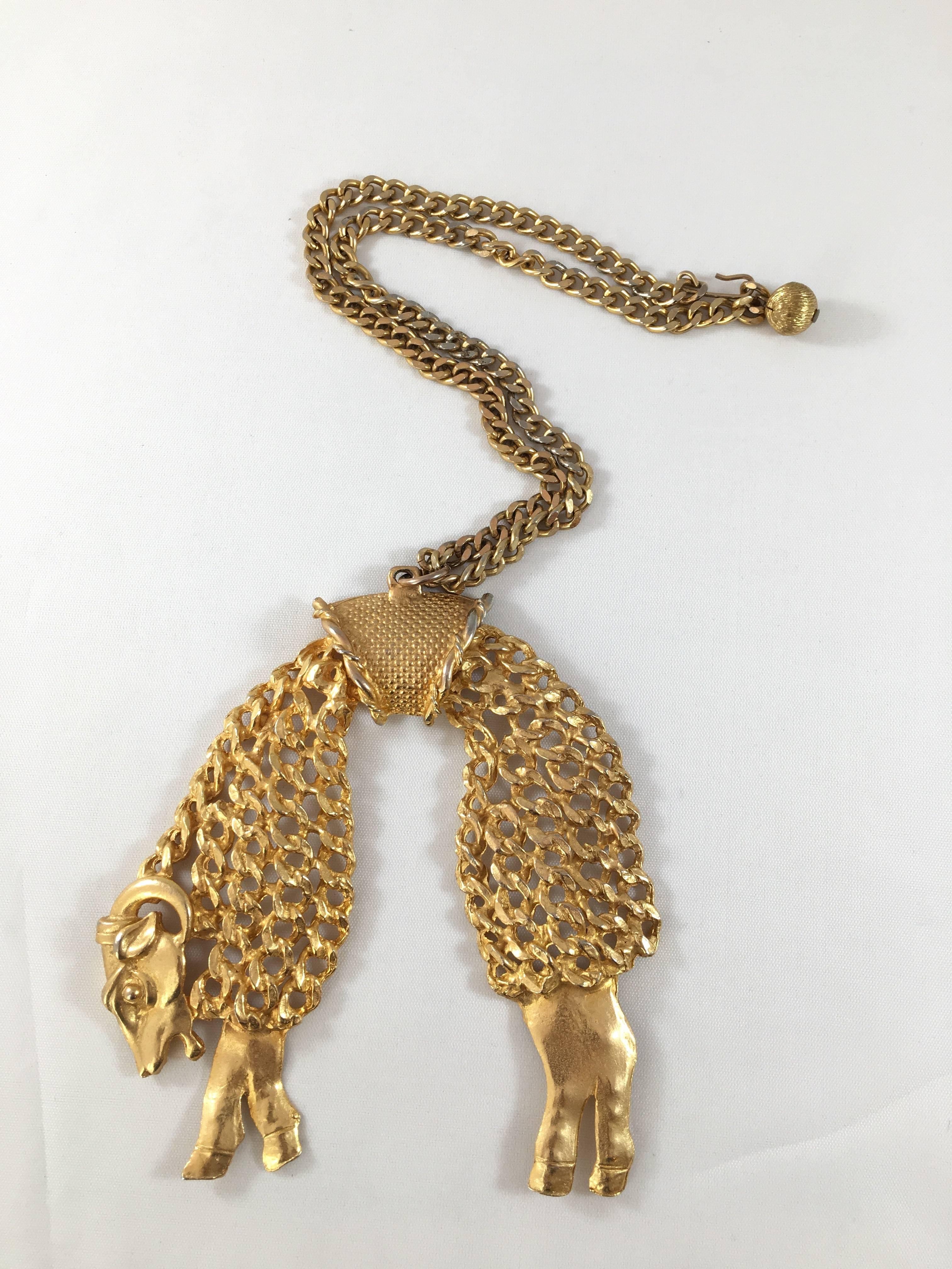 This is a rare 1970s golden fleece sheep pendant necklace from Kenneth Jay Lane. The pendant is huge. It measures 4 1/2" long x 3 1/2" wide. The chain is 18 1/2" long. The pendant is made up of two articulated sections - the front of