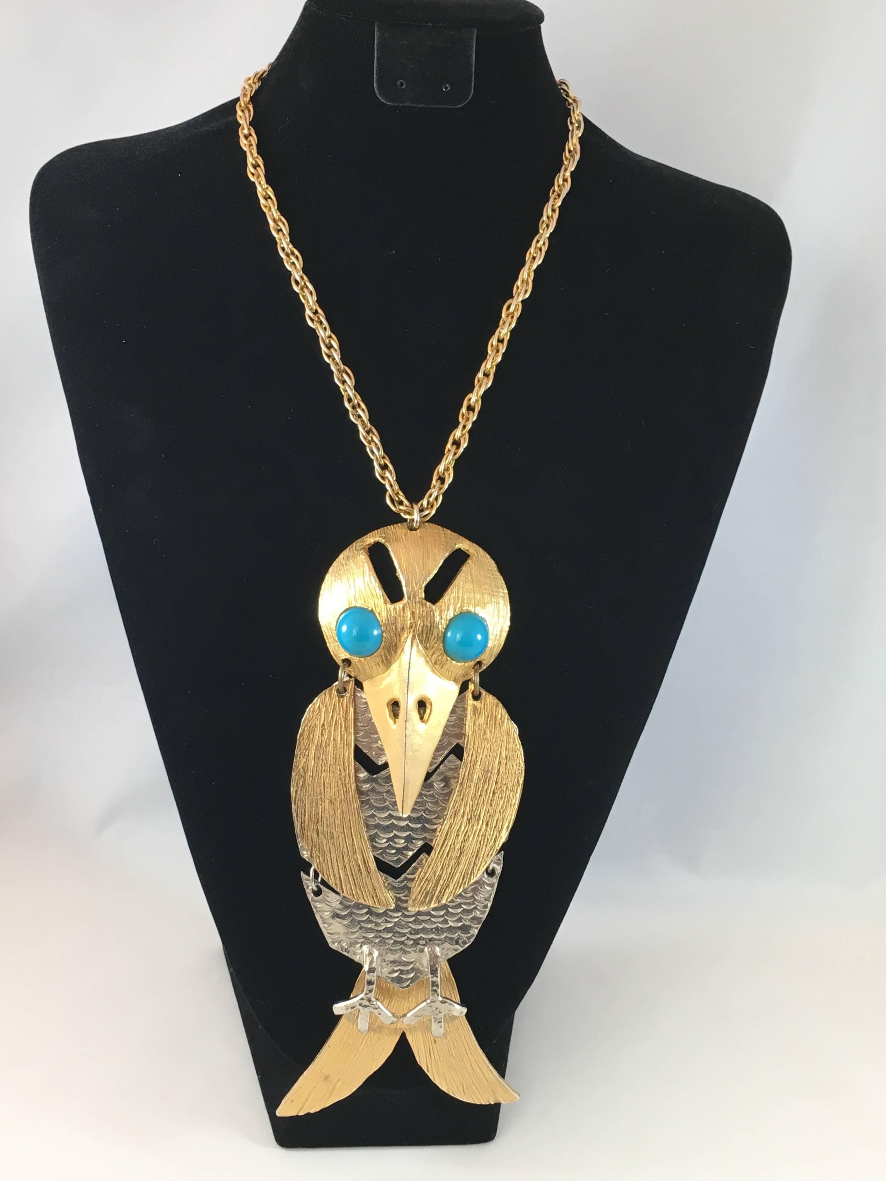 This is a huge 1970s bird pendant necklace from Kenneth Jay Lane. The pendant is enormous. It measures 7 1/2" long x 3 1/4"wide. The chain is 18 1/2" long. The pendant is made up of seven articulated sections - the bird's body, head,