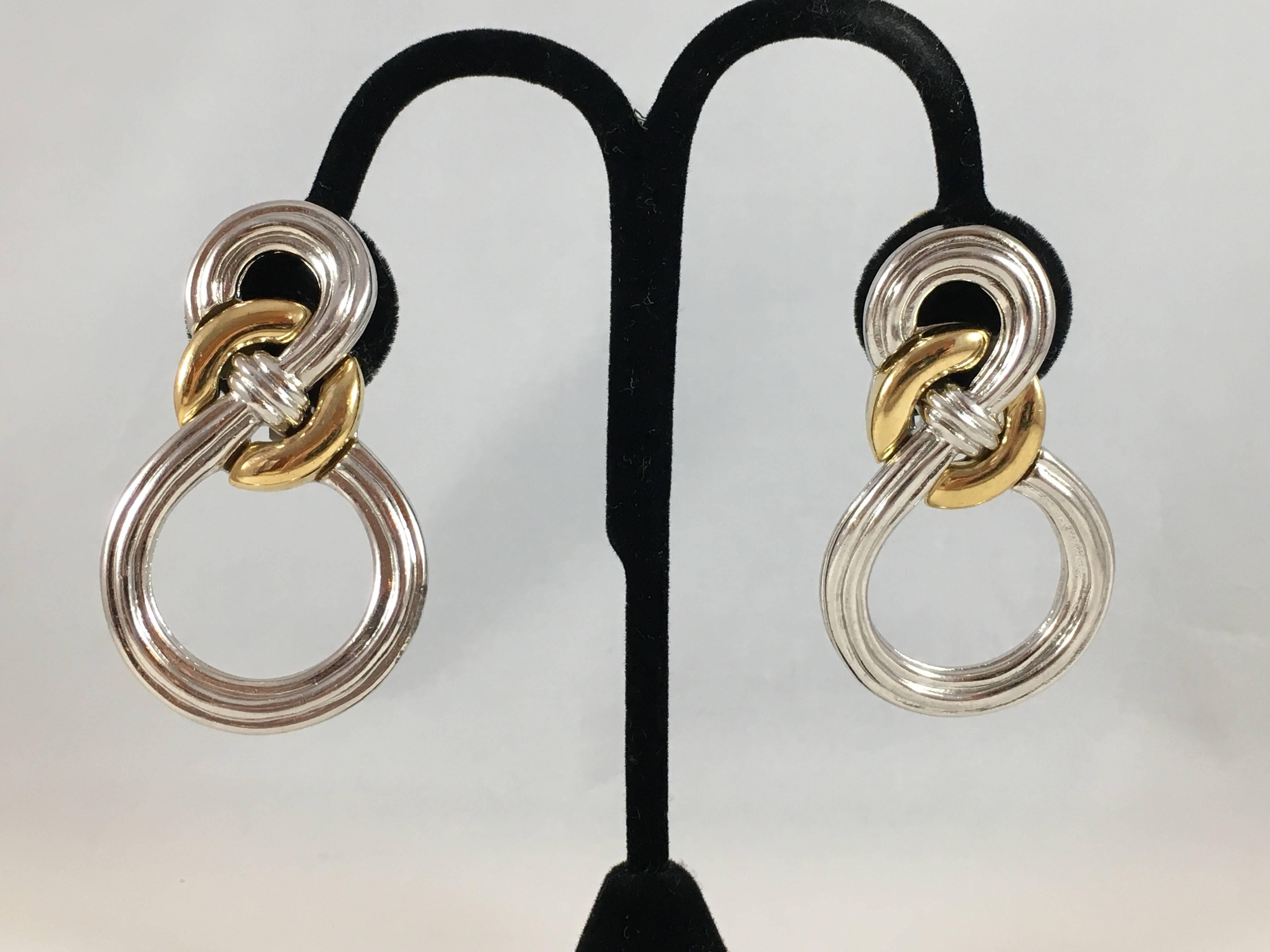 This is an amazing pair of large 1980s Givenchy clip-on earrings. They are made out of silvertone and goldtone metal. They are in excellent condition and signed 'Givenchy' in a plaque on the back of the earrings (see image 5). They are large,