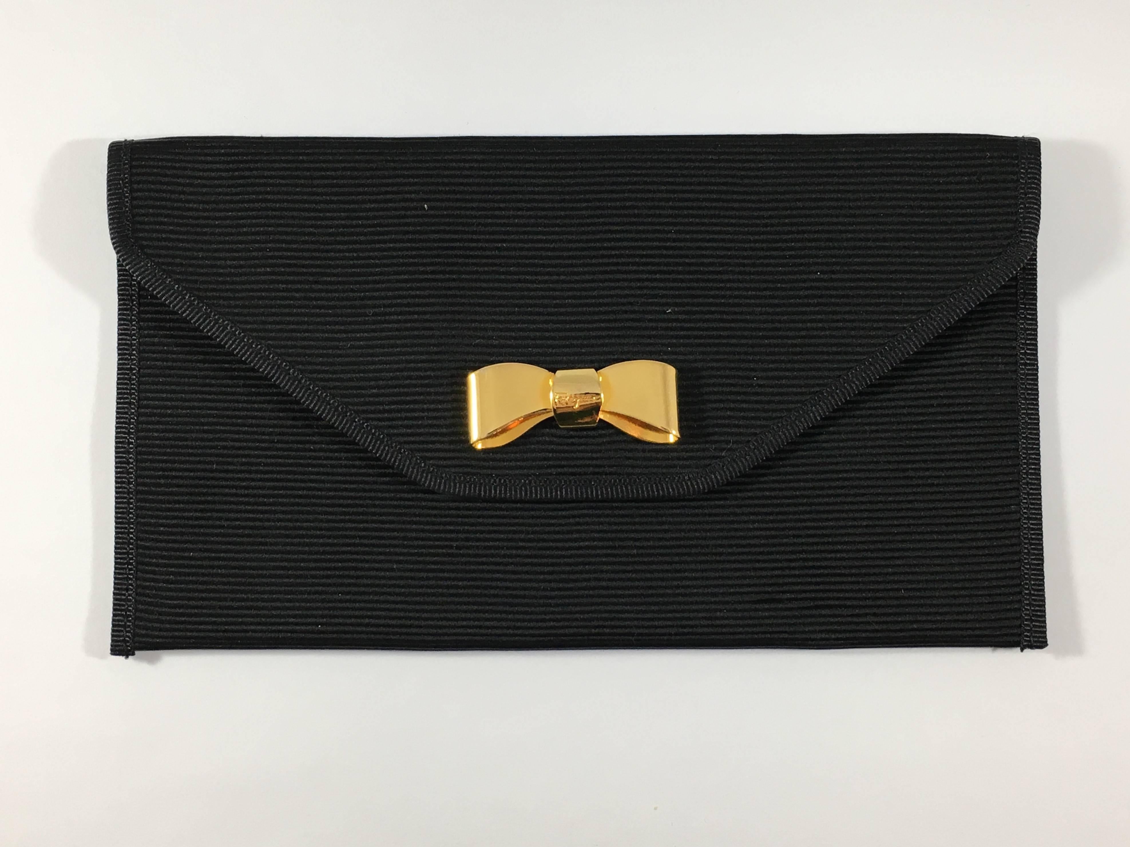 This is a small Ferragamo black grosgrain, leather-lined pouch that snaps at the front with signature Ferragamo goldtone bow. The interior is lined with soft black leather and has a tag that reads: SALVATORE FERRAGAMO MADE IN ITALY 22 0103. It