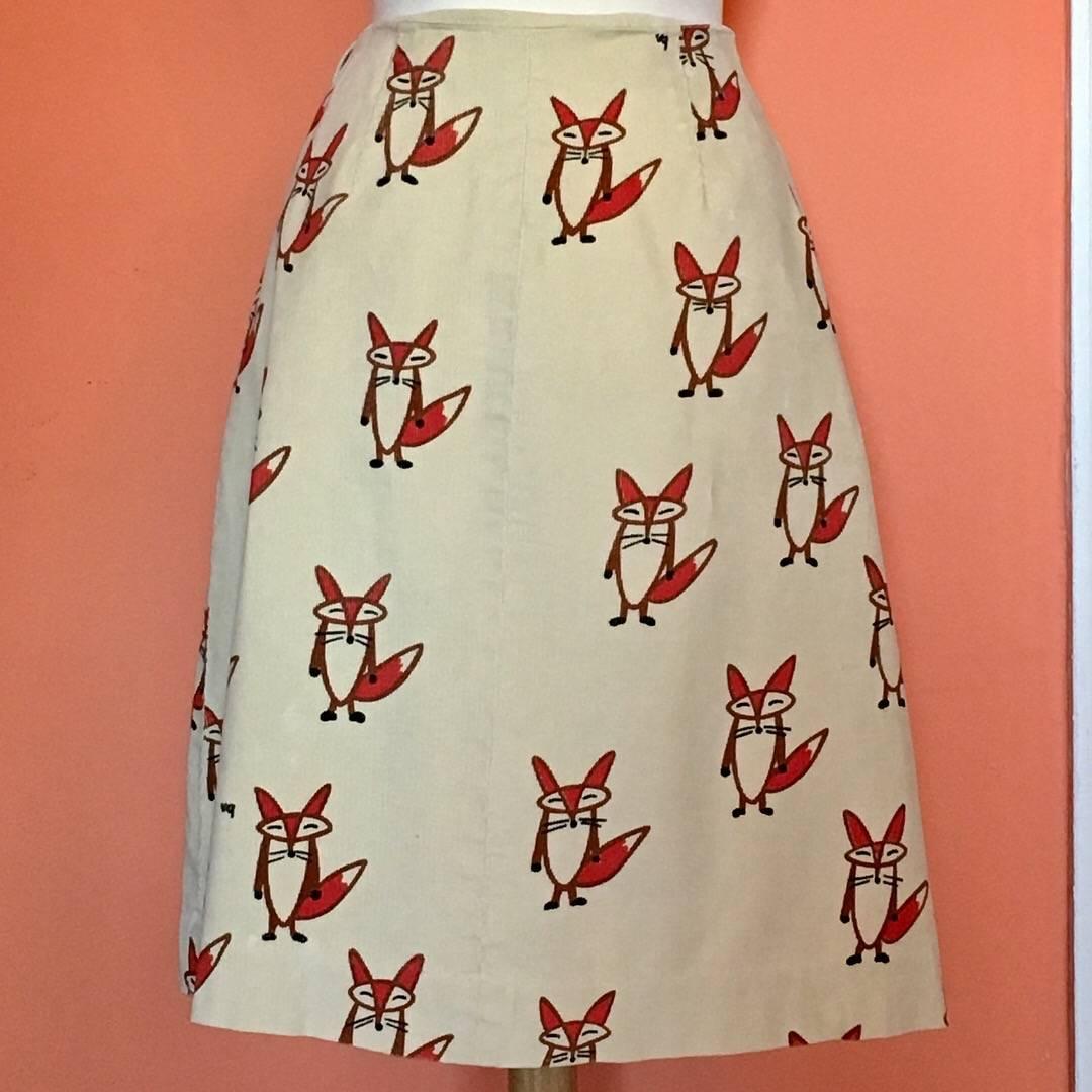 This is a 1960s tan corduroy Vested Gentress wrap skirt, silk screened with whimsical foxes and signed VG throughout the print.  It fastens with a hidden hook and eye and ties at the left hip. The skirt is in excellent condition. 

It is