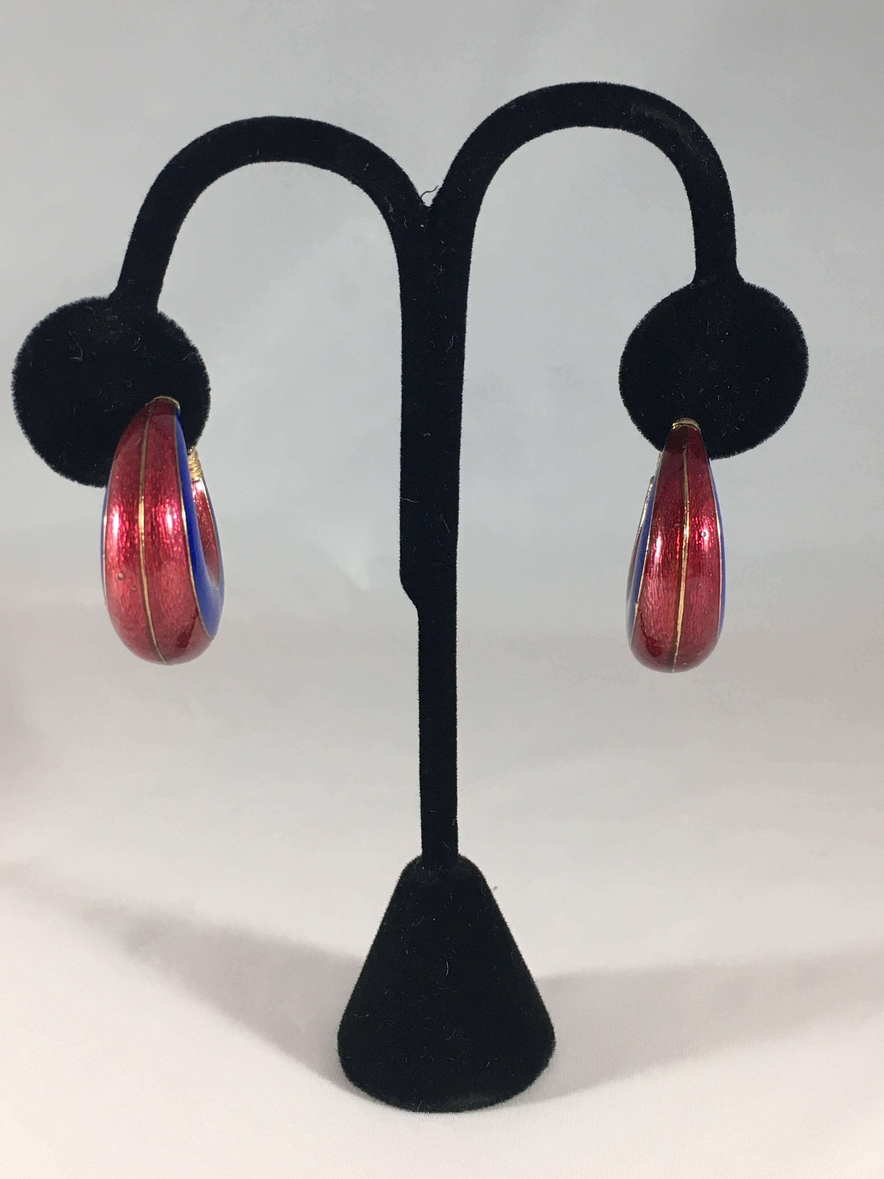 This is a pair of Ciner hoop earrings from the 1960s. They are gold tone clip-on earrings with blue and red enamel and are signed on the back of the earring clips. They are in excellent condition. They measure 1 1/4 inch long and 1/4 inch wide at