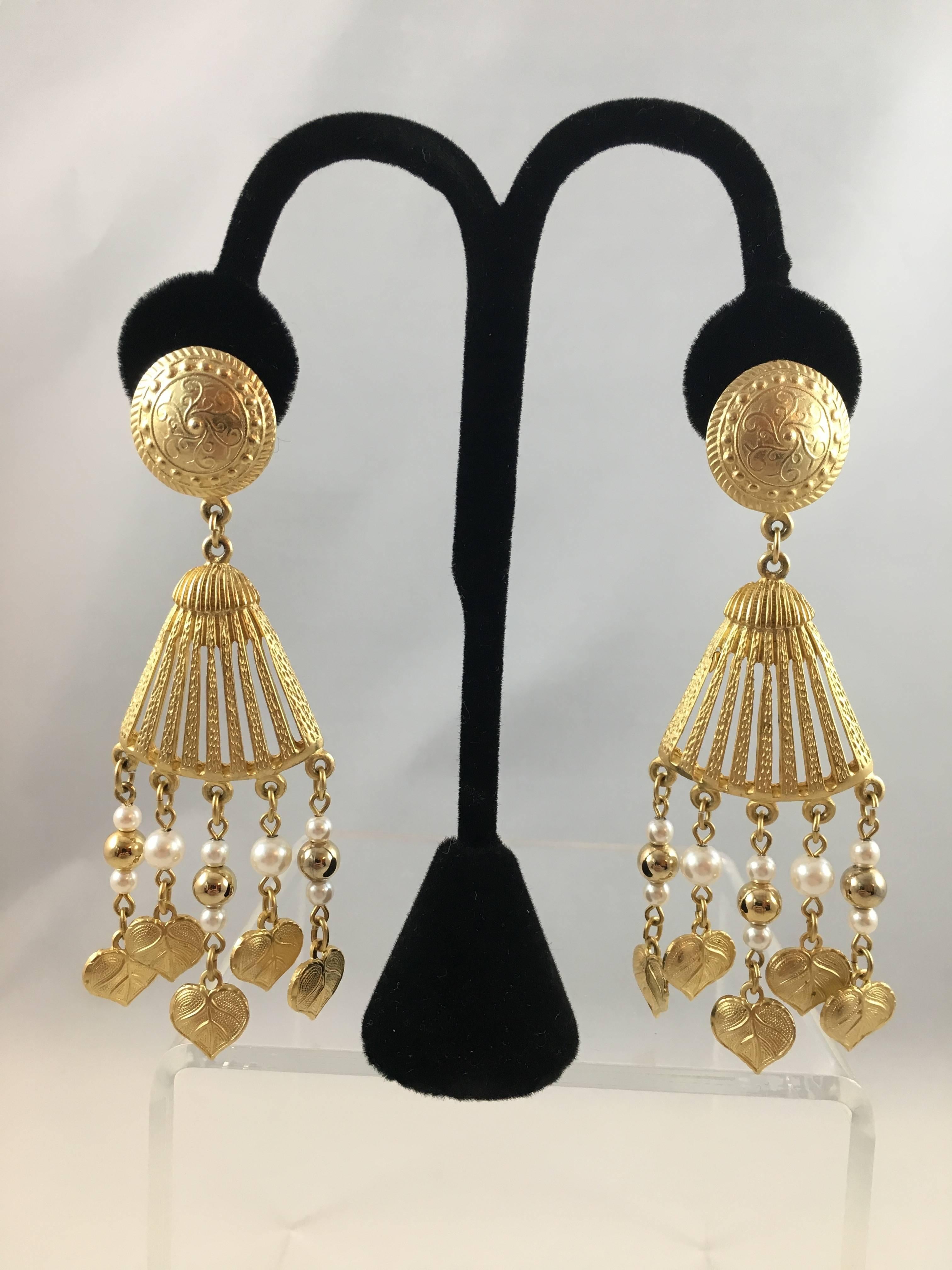 This is a large vintage pair of Givenchy dangle clip-on earrings. They measure 4 inches long and 1 1/4 inch wide. They each feature five chains with faux pearl and gold beads hanging down. They are in excellent condition and signed 'Givenchy' in a