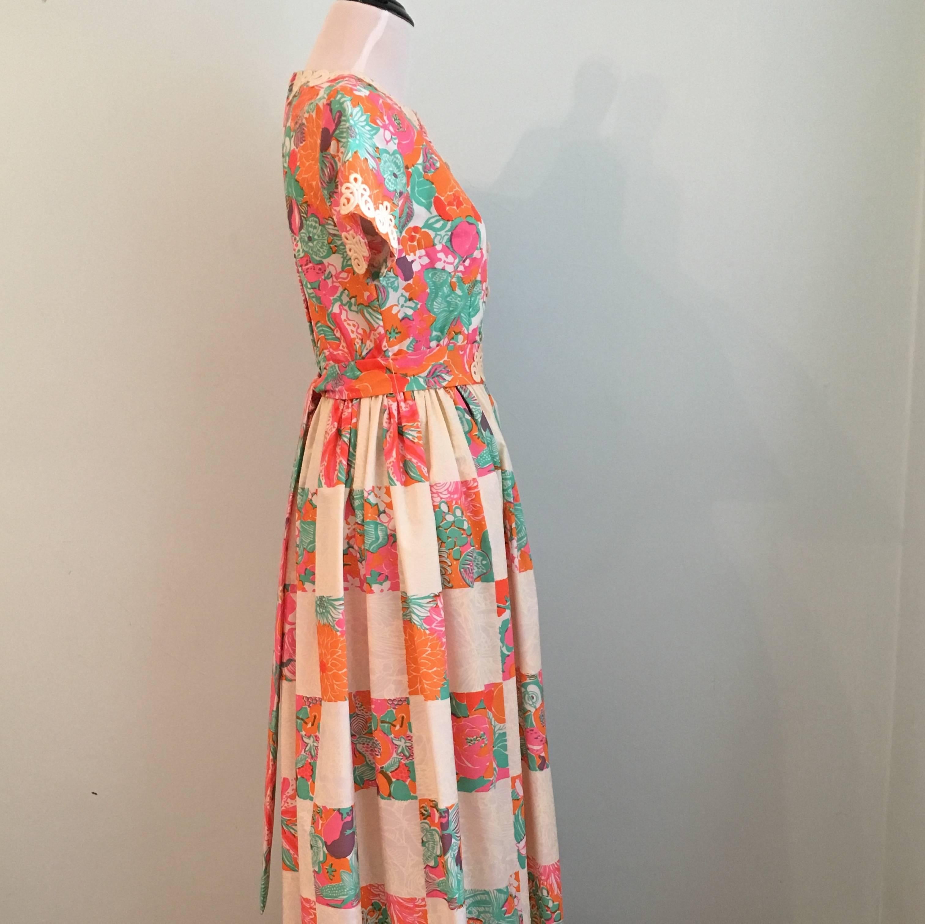 This wonderful Lilly Pulitzer dress dates to the mid 1960s. The bodice is made up of a pink, orange, green and white colored fruit, floral and butterfly print. The skirt is made up of a patchwork printed fabric. There is a size tag on the dress that