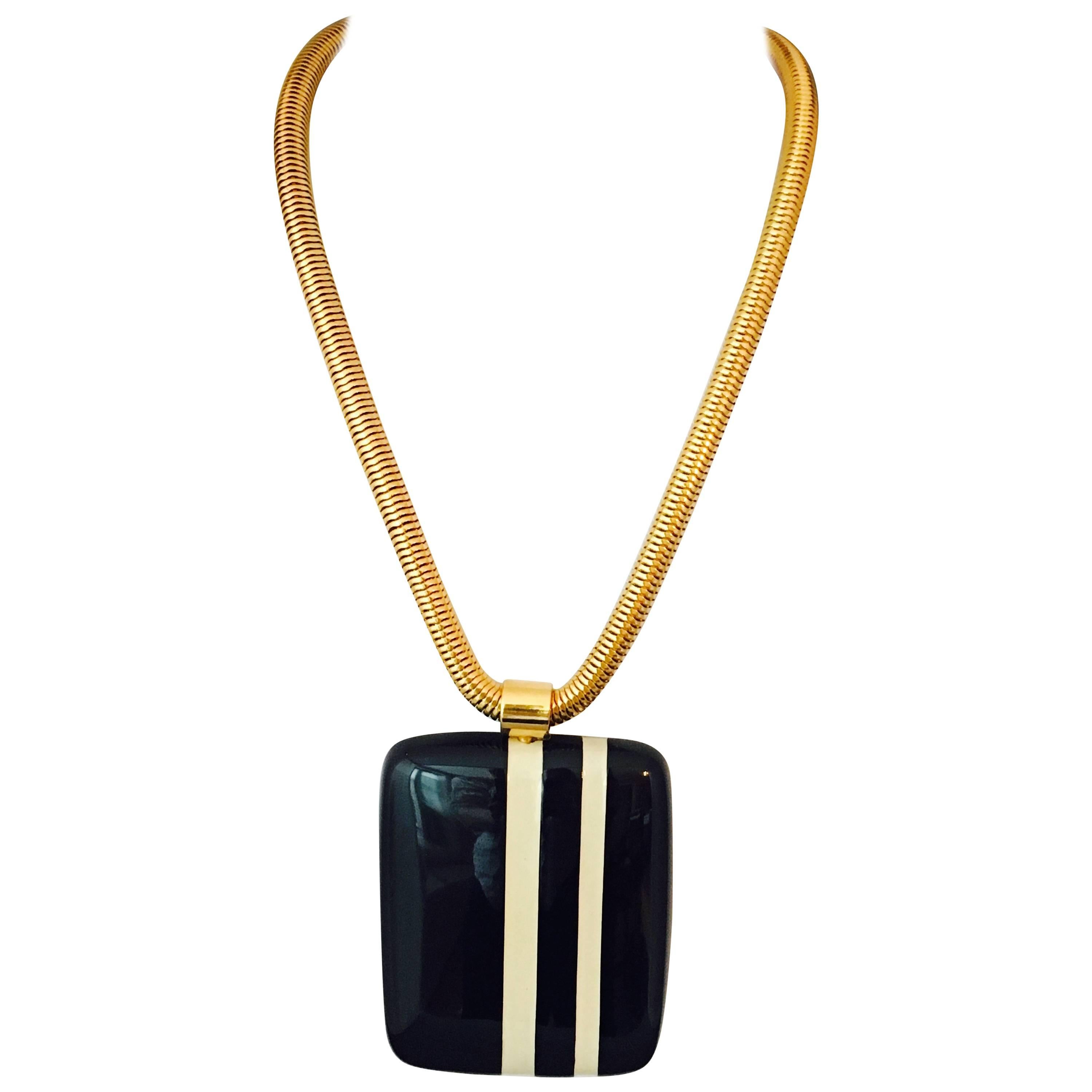 This is a fabulous 1970s Lanvin navy and white striped pendant necklace. The large pendant is made out of a substantial resin and hangs from an 18 1/2 inch long snake chain. The pendant measures 3 inches long x 2 3/8 inches wide x 3/8 inches thick.