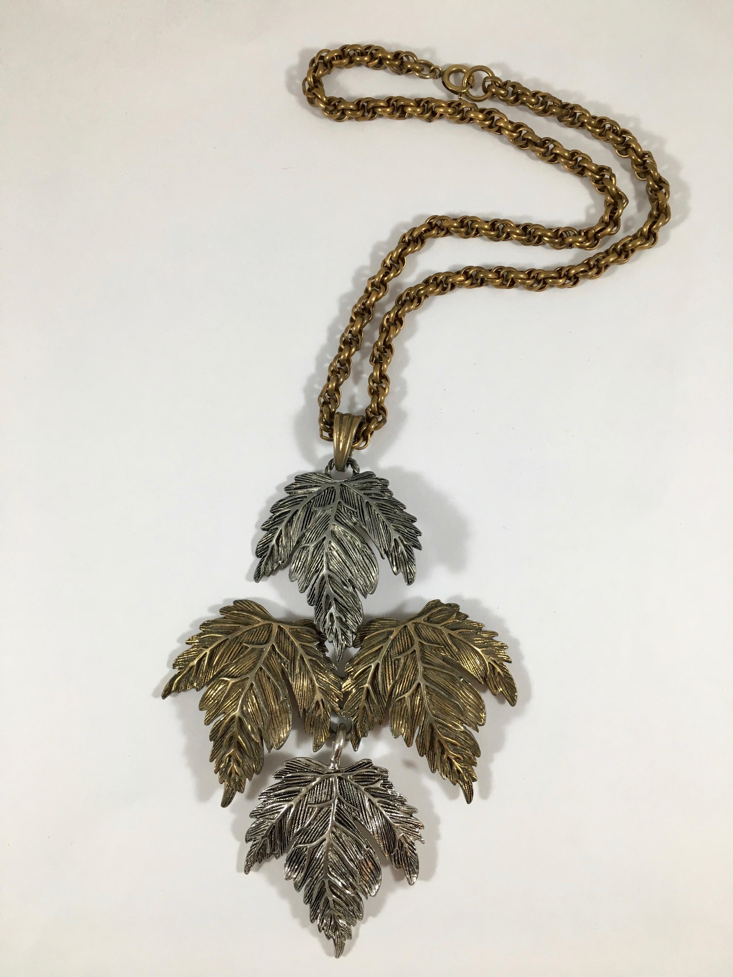 This 1950s Castlecliff necklace has a huge beautifully detailed leaf pendant made up of two silver colored leaves and two copper colored leaves. The pendant measures 5 inches long x  3 5/8 inches wide and hangs from an 18 inch copper colored chain