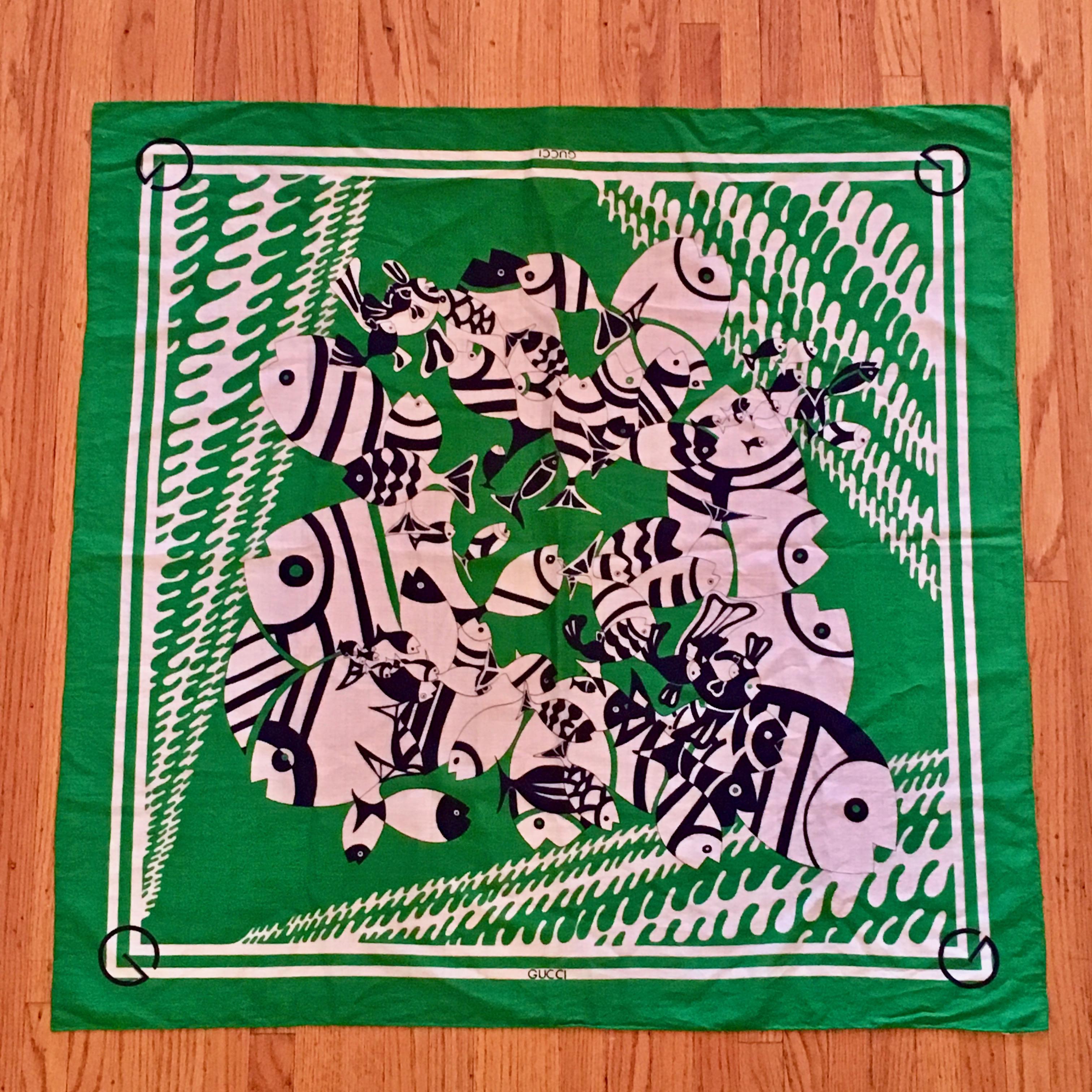 This is a fabulous and rare 1970s MOD cotton Gucci scarf featuring a green, navy and white fish print - such a fun period piece. The edges are hand-rolled and stitched. Each corner features a navy Gucci 'G'. On the back there is a tag that reads