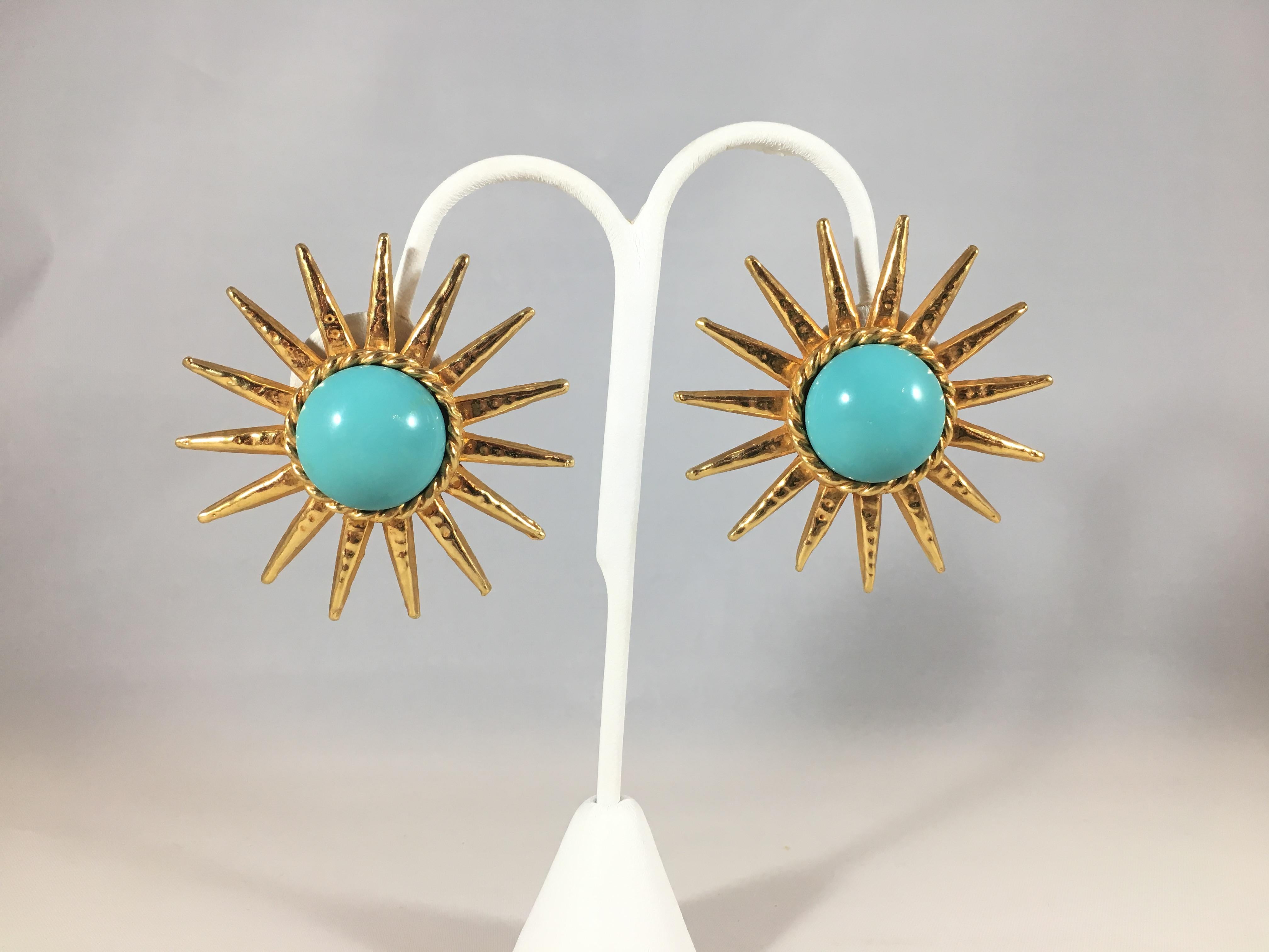 This is a stunning pair of large gold-tone Phillipe Ferrandis clip-on earrings with glass turquoise colored centers. They are in excellent condition and measure 2 3/16 inches in diameter. They are marked 'Phillipe Ferrandis' on the backs of the