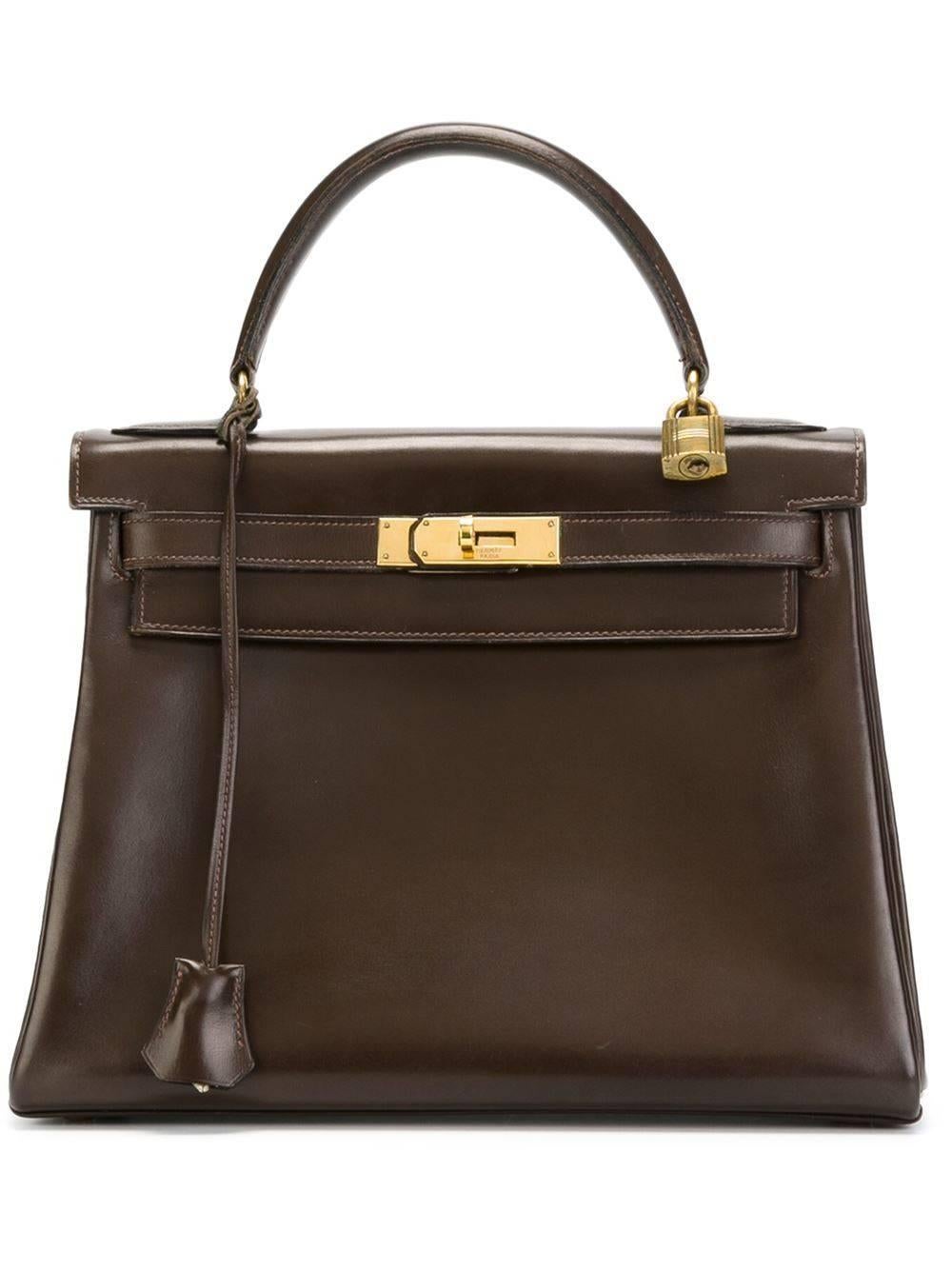 Hermès Rarity. The Kelly handbag of 1958. In exceptional condition. See pictures. Fabulous brown calf-box leather quality.  Gold hardware finishing. Marked Hermès Paris, letter N. 28 cm.  Delivered with the Hermès' Twiggy and the certificate.  