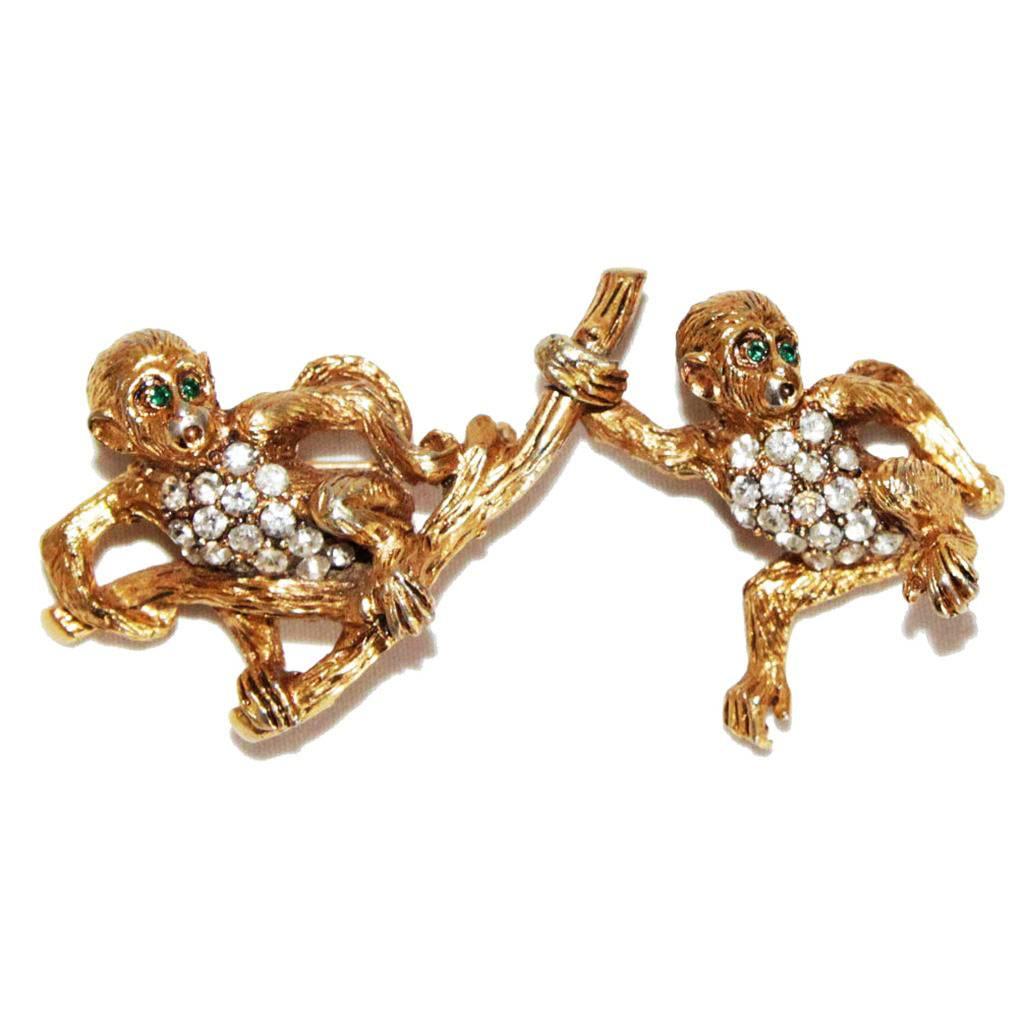 Unique and exceptional double monkeys vintage brooch of the 60s, dangling monkeys, articulated. Unsigned. Certainly made in the US. Made of gold plated metal and embellished crystal stones & emerald crystal eyes.

Excellent vintage condition. Size