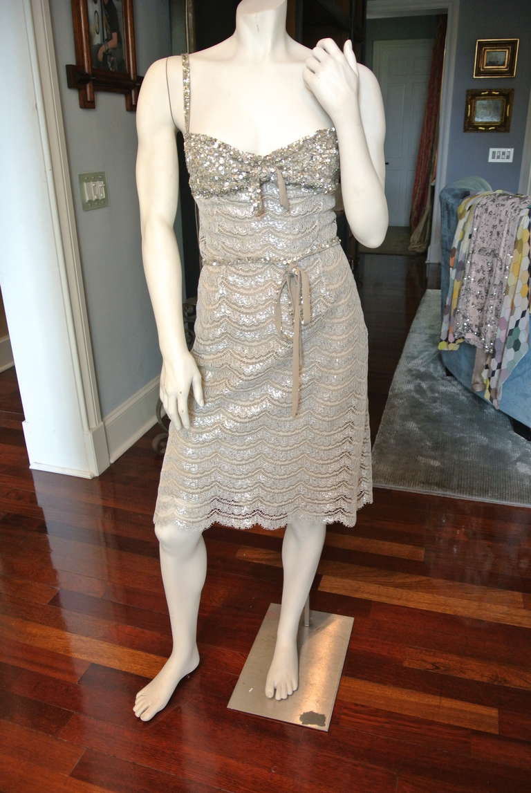 Striking lace and sequin short length cocktail gown with silver metallic highlights.