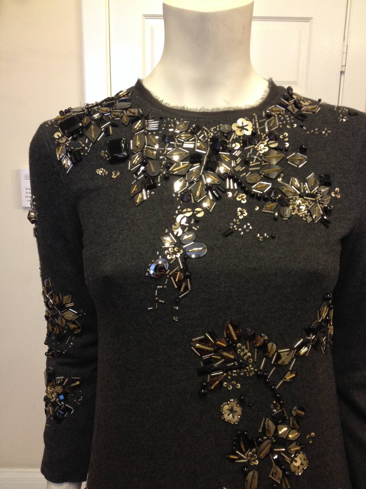 A dress for when you want to look truly breathtaking - this Lanvin is impeccable. Patches of sequins, rhinestones, and tiny glass beads make flower-like formations that that float across the material, punctuating the luxurious charcoal grey