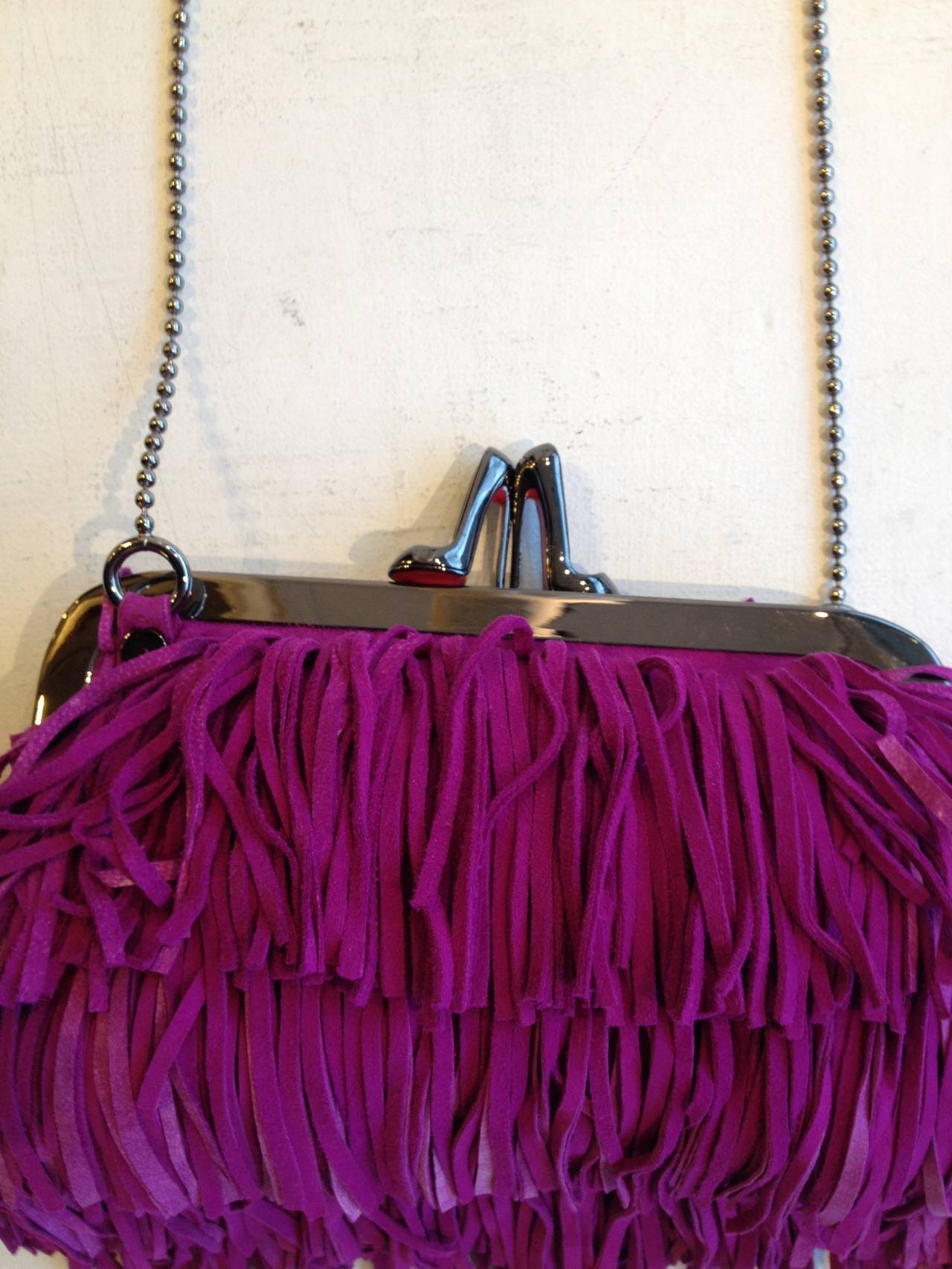 The perfect bag for any Louboutin devotee - covered in a cascade of bold orchid purple fringe, it has the same wild and fun aesthetic that Christian Louboutin is known for. The fine pewter-toned chain strap drops 18.5 inches from the top to the top