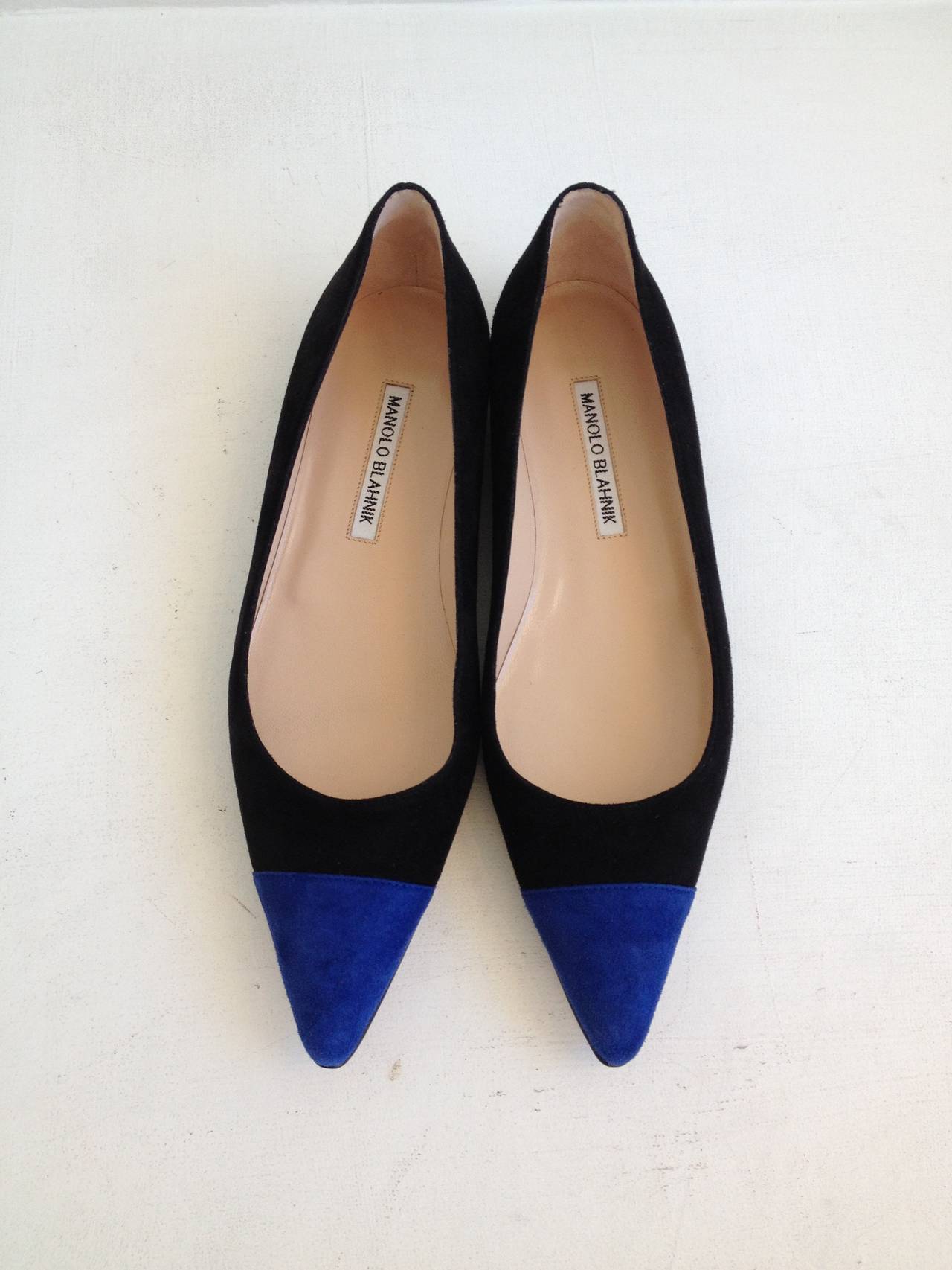 Bold, graphic, modernist - these Manolo Blahnik flats make such an impact! Velvety black suede is accented with a deep cobalt blue cap toe, adding a cool punch to the sleekly pointed skimmer style. Wear with black cropped skinny trousers and a boxy