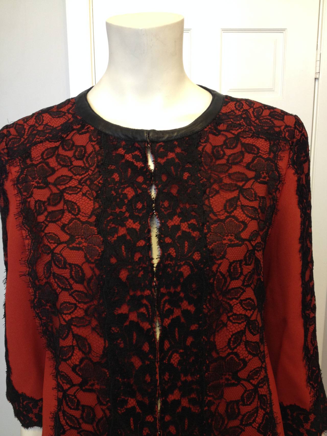 It's difficult to make delicate black lace feel bold and new, but Andrew Gn has done it with this piece. Overlaid over a beautiful and modern cleanly cut rust red coat, it creates a beautiful silhouette against the bright color and forms lovely