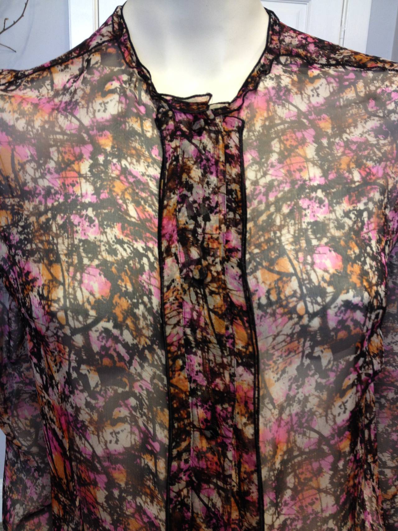 We'll never tire of Bottega Veneta and their timelessly elegant luxury. This blouse features an intricate and beautiful print of tangerine orange, bright magenta purple, and deep brownish black dynamically splashed across a white background. The
