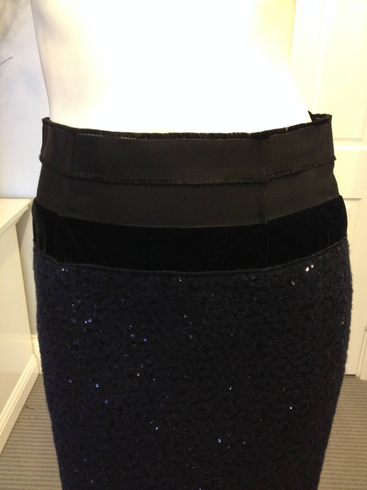 This skirt has the most beautiful textures. The waistband is made from a combination of two black grosgrain ribbons and one black velvet ribbon, while the skirt is a gorgeously plush nubby navy wool embedded all over with black sequins. The cut is