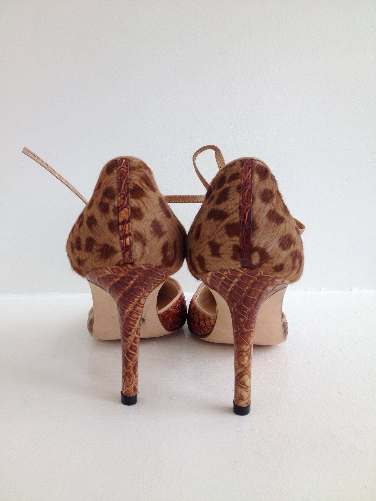 Animal madness! With a faux alligator toe and a leopard print pony hair heel, these Manolo Blahnik d'Orsay heels are fierce in so many ways. The toe comes to a sharp point, while the heel wraps around to tie at the ankle. The 3.25 inch stiletto is