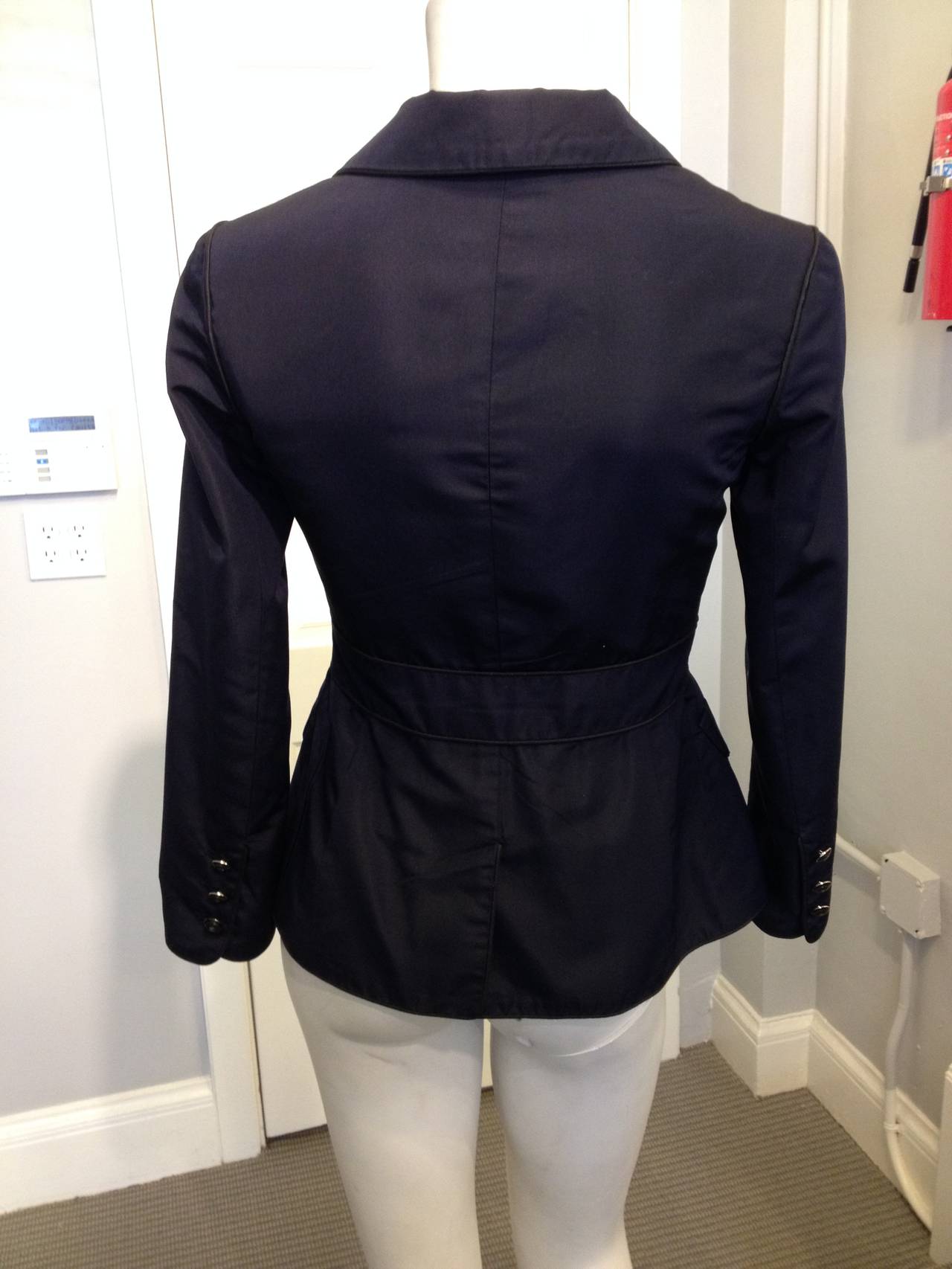 We love the simplicity of this beautiful jacket - from the 2007 Cruise collection, it's perfectly chie. The deep blue silk twill is trimmed with black piping along the seams for contrast and definition, while the four pockets add gamine Marine