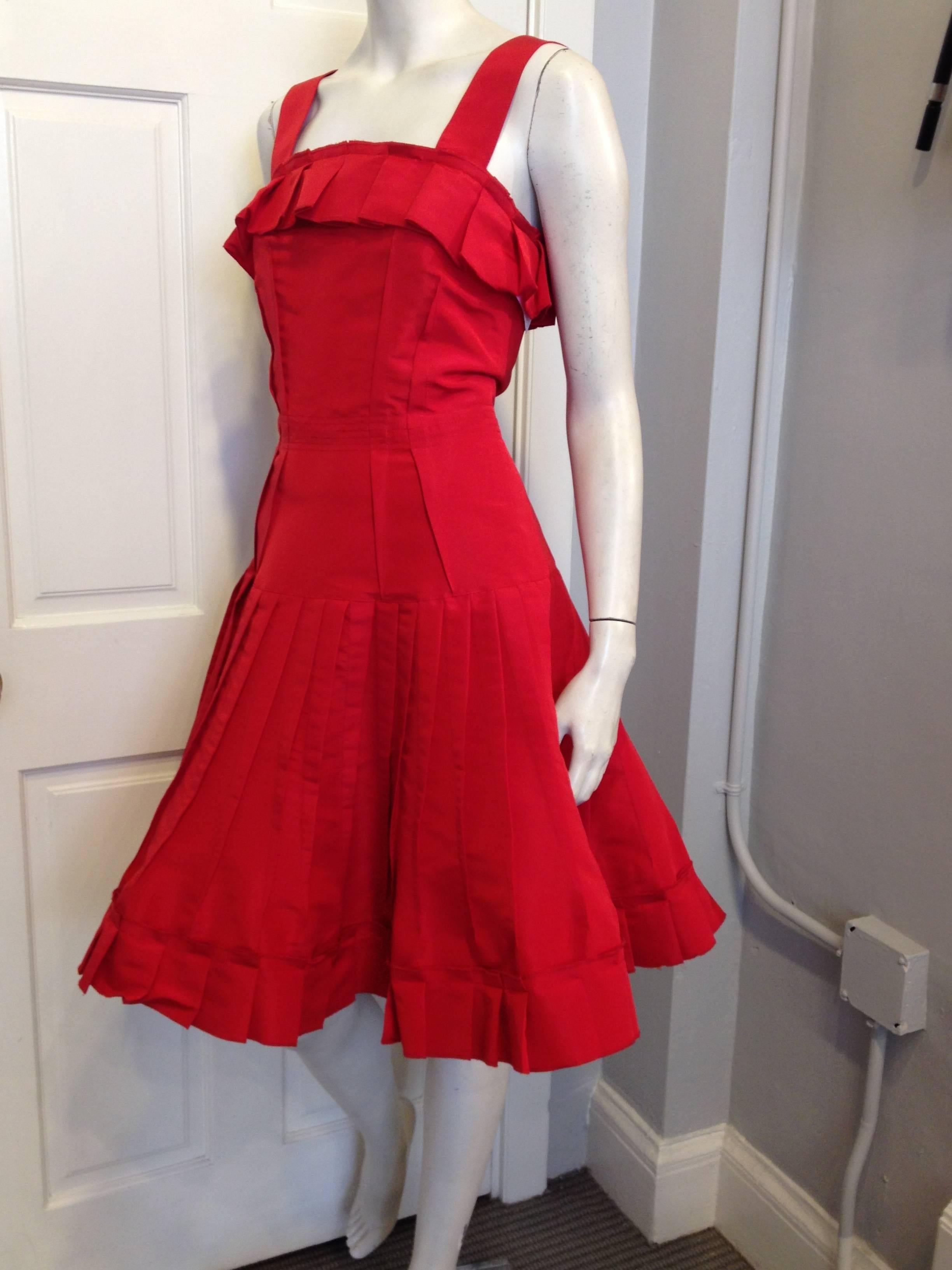 There's nothing more iconic than a cherry red dress, and Oscar de la Renta made ones of the best. This piece is fun but elegant, lively but timeless - the wide shoulder straps are offset by the big box-pleated ruffle lining the bust, which is