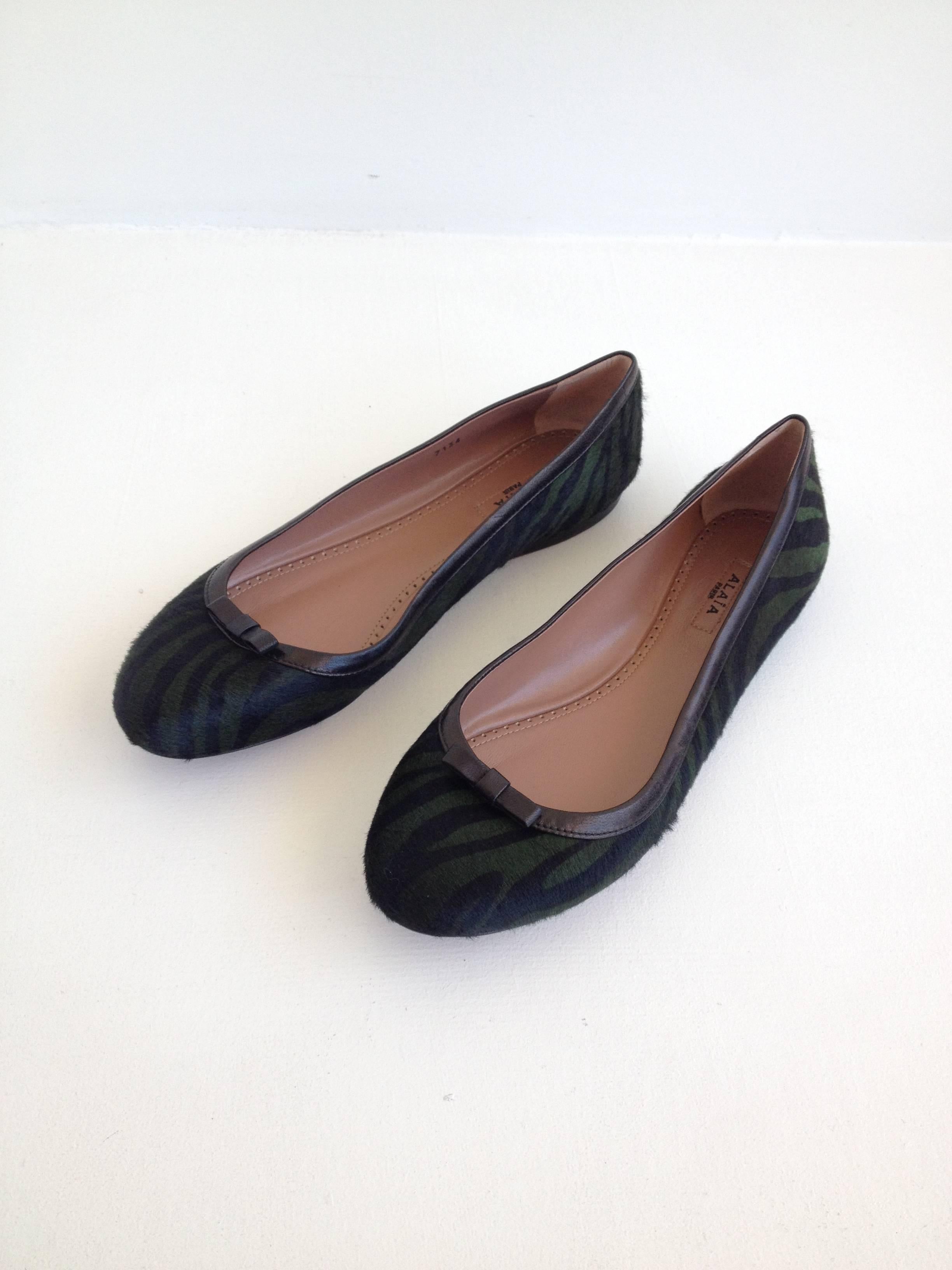 Made from incredible ponyhair dyed with deep forest green and black zebra stripes, these shoes have a little more edge than your typical ballerina flat. The toe is trimmed with a delicate little bow. Alaia makes the most beautiful things and these