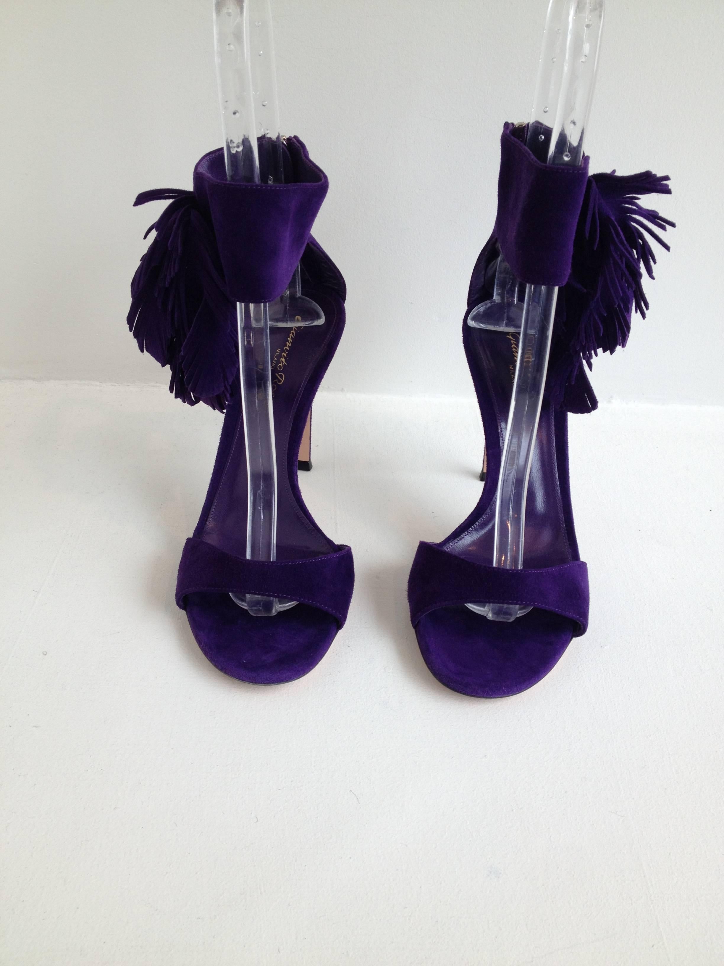 Perfect for summer! This striking and dramatic shoe is made from a gorgeous purple suede, minimalist in cut but embellished with a fabulous little pouf of suede feathers like fringe at the ankles. The heel is four inches and the shoe zips up the