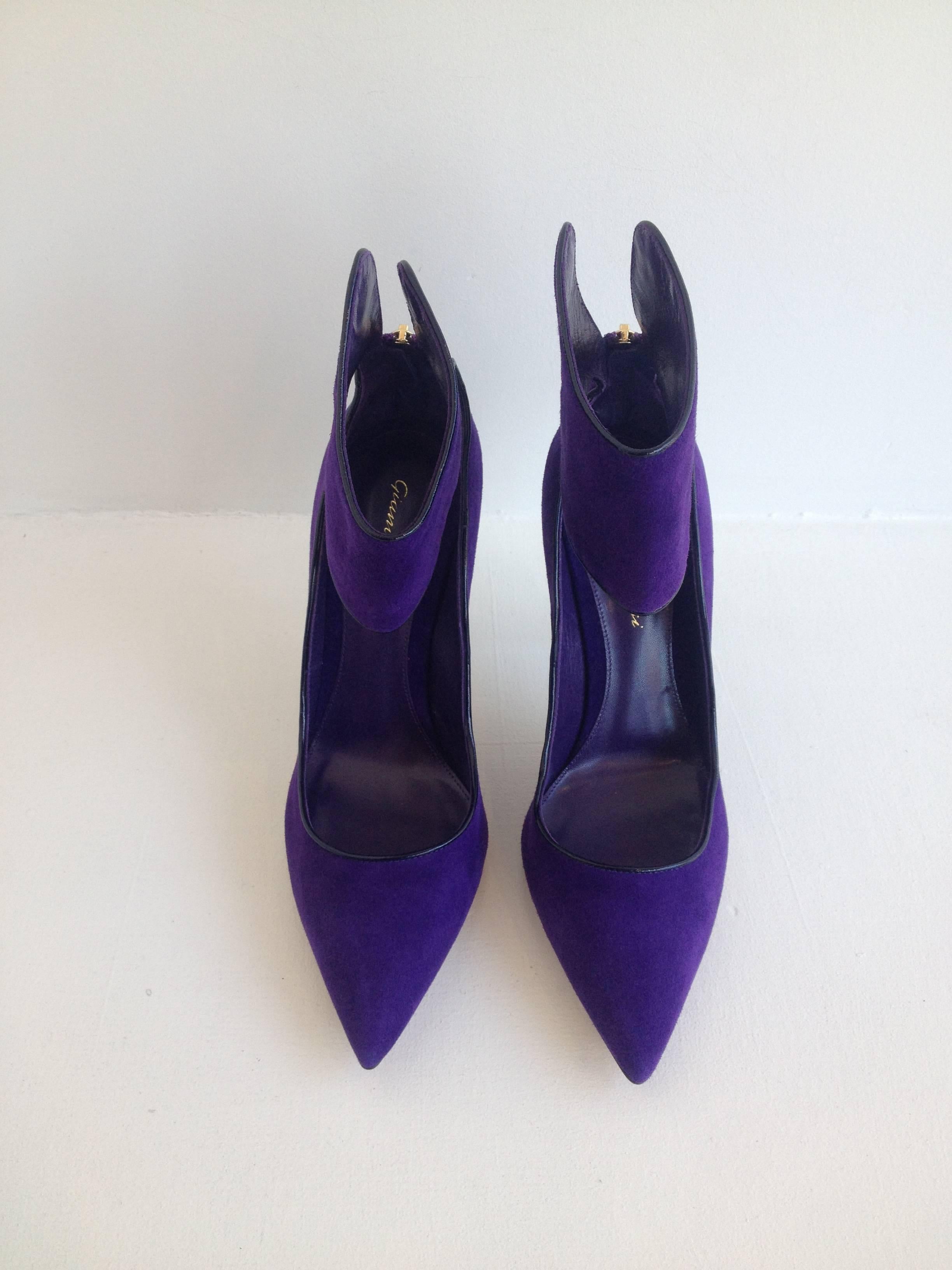 Vibrant and vivid purple suede is sure to turn heads. These heels feature a sleek pointed toe and a 4 inch stiletto heel for a classic silhouette, but a wide ankle cuff adds a very modern edge. The edges are lined with black piping and the gold