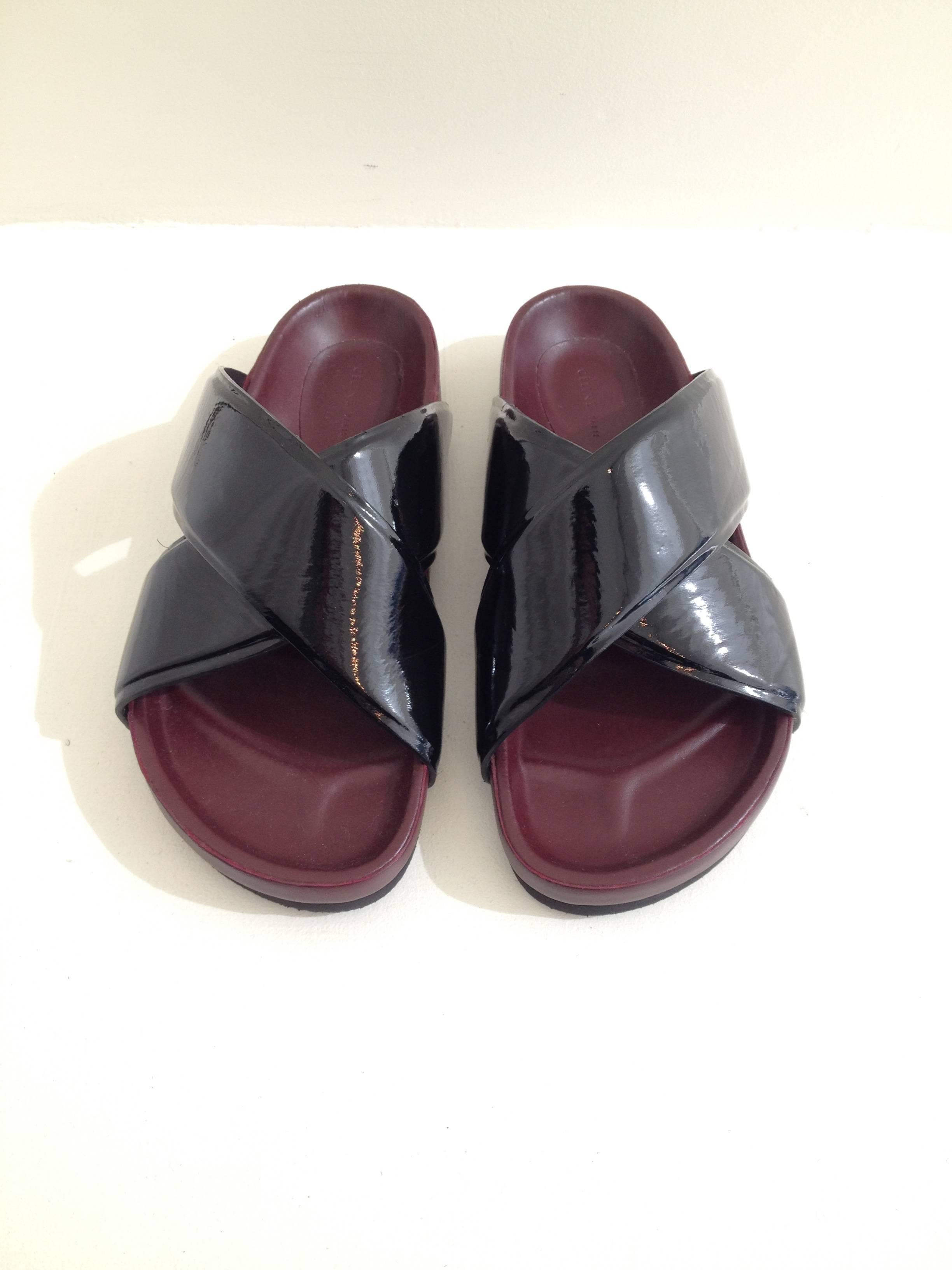 Slide right into summer. These flat sandals by Celine are on-trend and perfect for the season - the thick, contoured, Birkenstock-esque sole are super comfortable and easy to wear, while the wide patent crossed straps add a little shine. These are