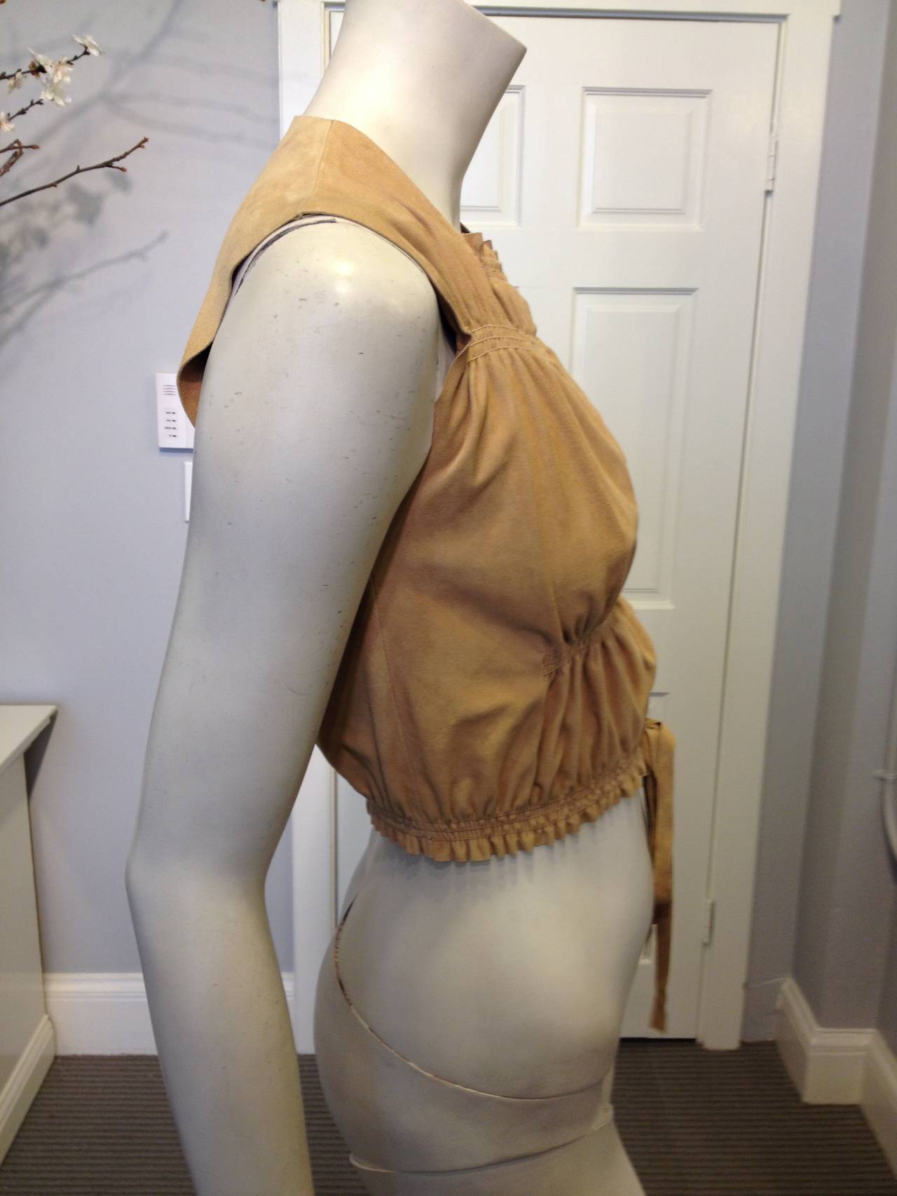 Ultra soft suede makes this Jean Paul Gaultier top something truly special. With a high neckline, sleeveless cut, and cropped hemline, it's perfect for anything from a festival or summer road trip to an afternoon in the park with your friends.