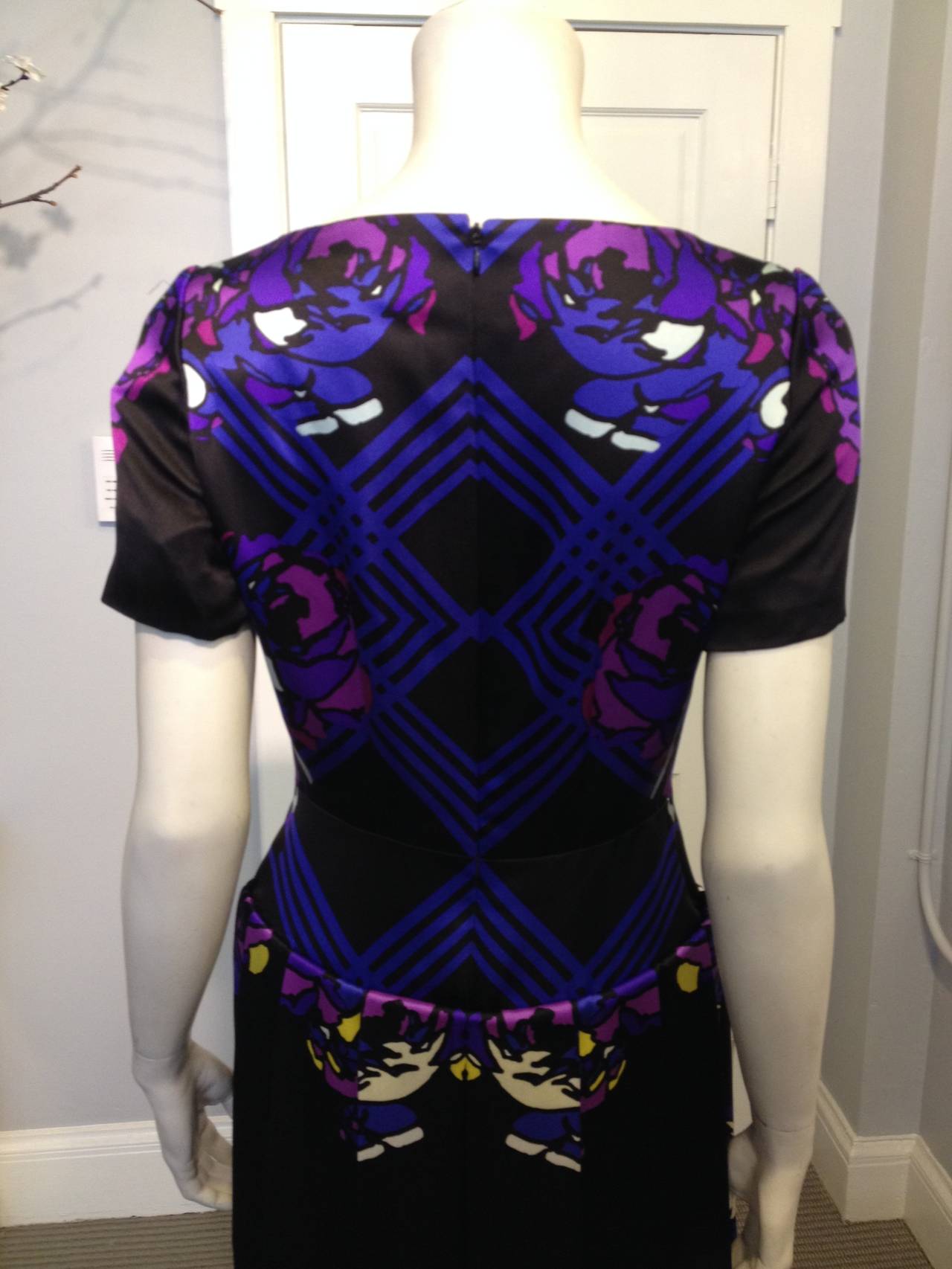 This gorgeous Honor dress is resplendent in deep violet purple and vibrant blue - looming out of the black background, the stylized stenciled flowers and geometric stripes are lively, bold, and impactful. The heavy satin material has a beautifully