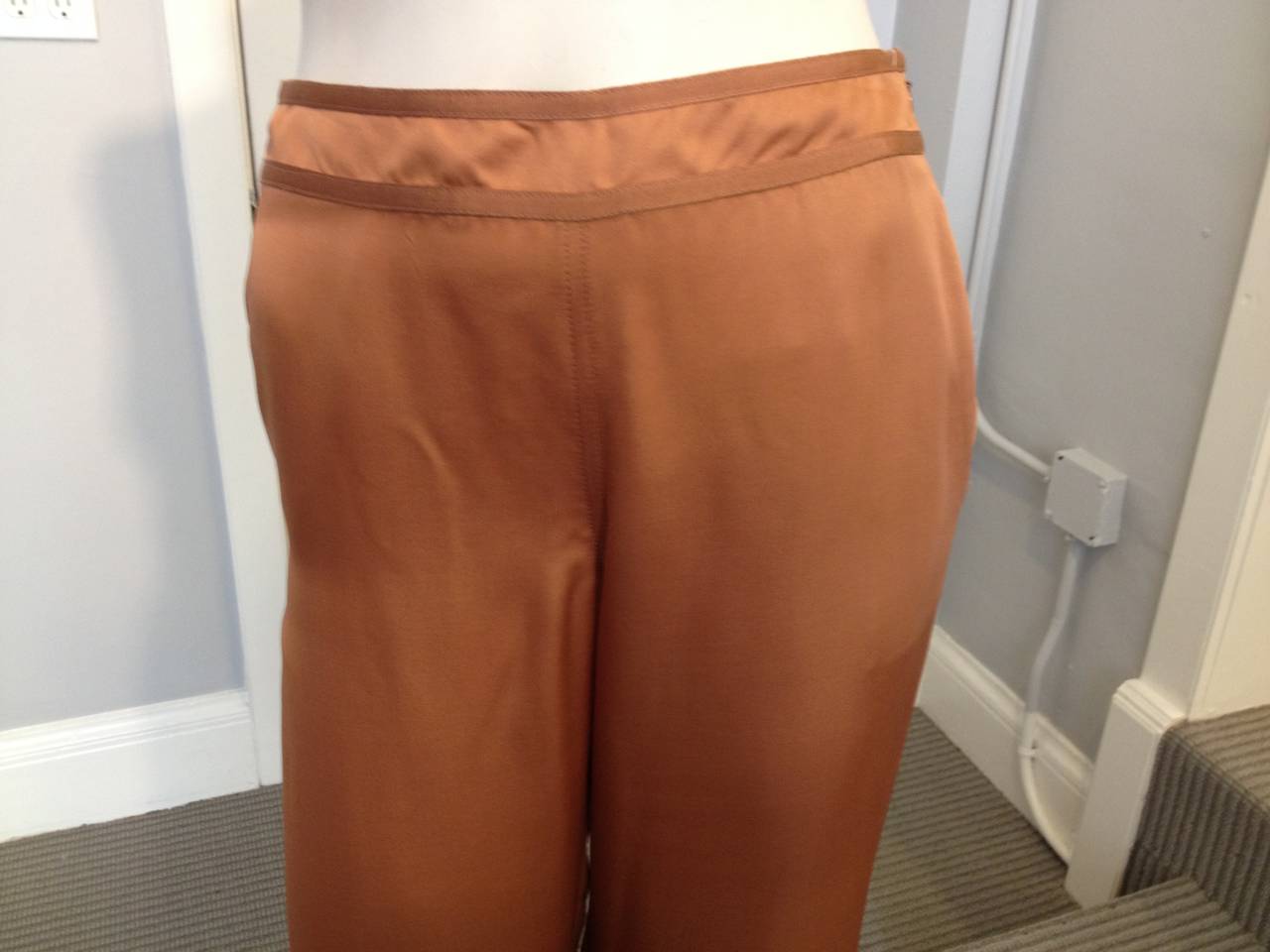 Deep peachy orange silk makes a dramatic statement, especially on these beautifully billowing Margiela pants. The waistband and cuffs are lined with thin grosgrain ribbon in a matching color, and each hip features a slip pocket. Perfect for warm