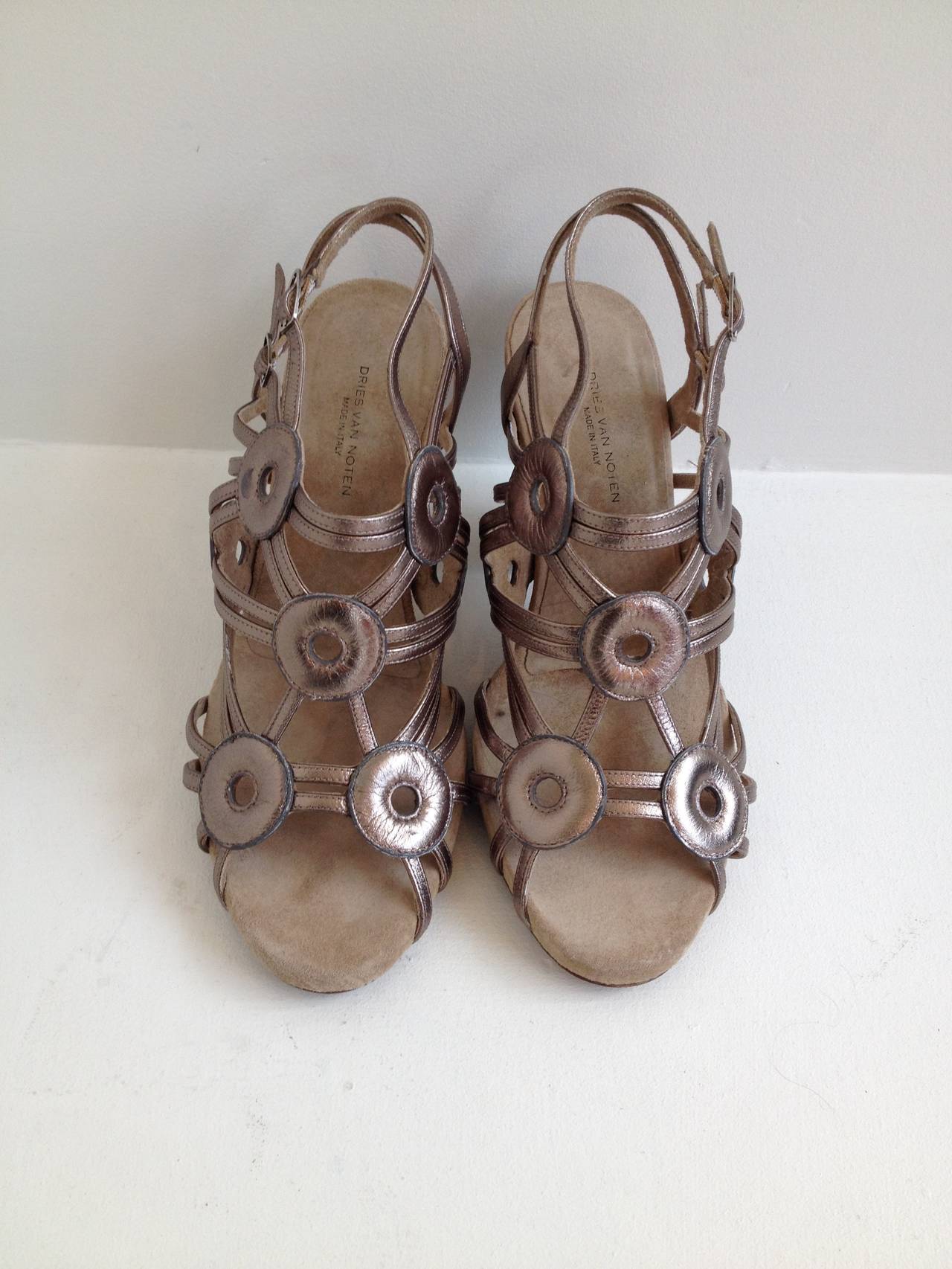 These Dries shoes are the perfect way to wear metallic - the finish is glossy but textured, while the color is somewhere between a bronze and a frosty silver. The strappy body is decorated with five leather discs shaped like donuts. Wear these